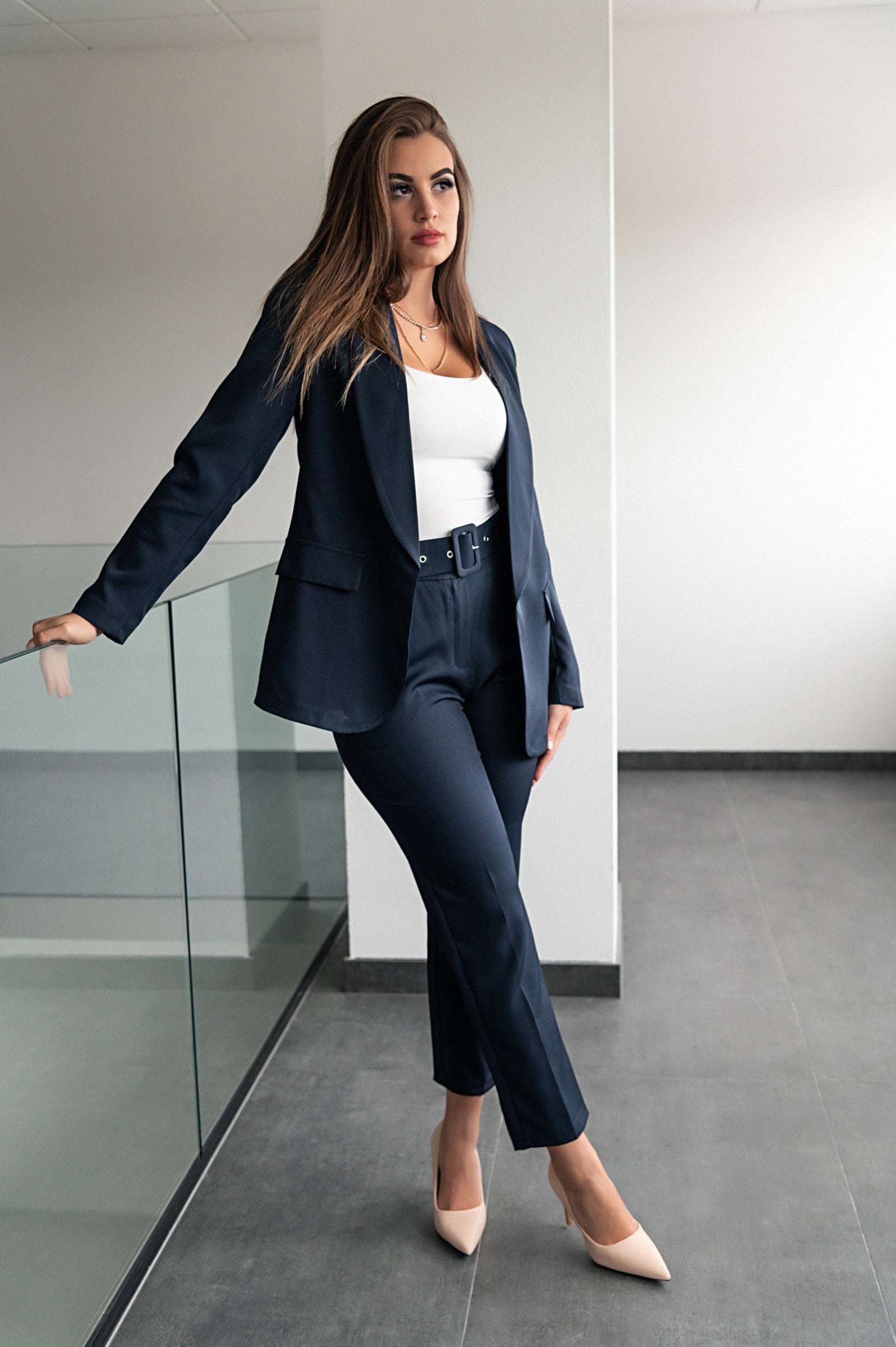 Elegant dark blue blazer and pants set, featuring long sleeves, classic collar, and attached belt, made in Italy.