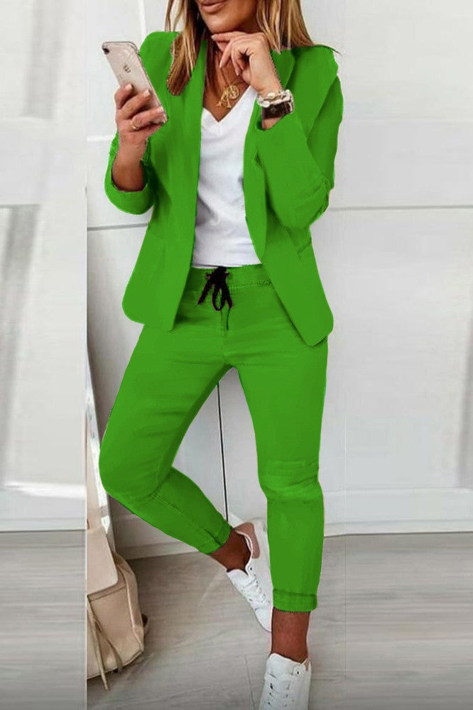 Elegant green blazer and pants set Estrena, featuring long sleeves, classic collar, and fitted pants with drawstring.