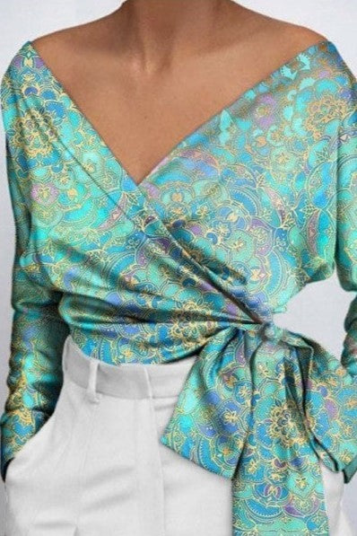 Elegant light blue blouse with print, featuring a crossover V neckline and bow tie detail on the side, made from high-quality imitation satin.