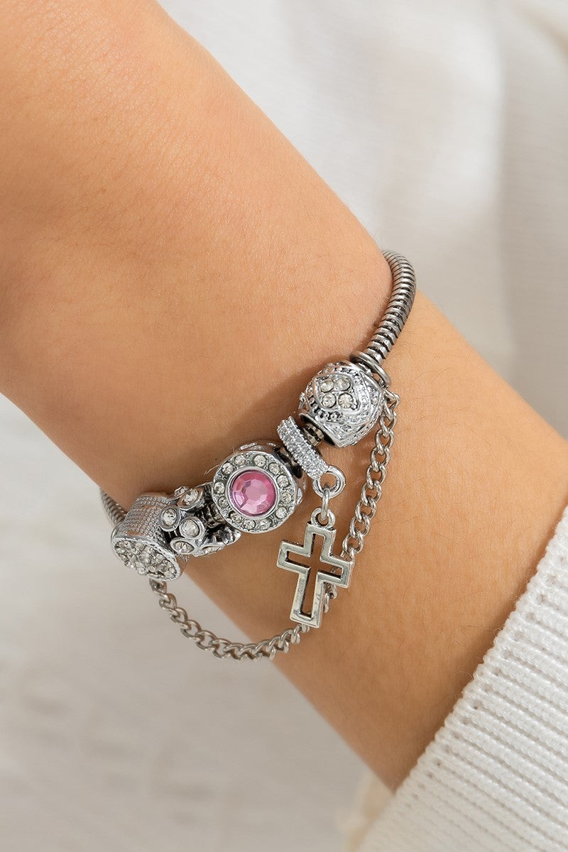 Elegant silver bracelet featuring decorative pendants and rhinestones, secured with a metal pin closure.