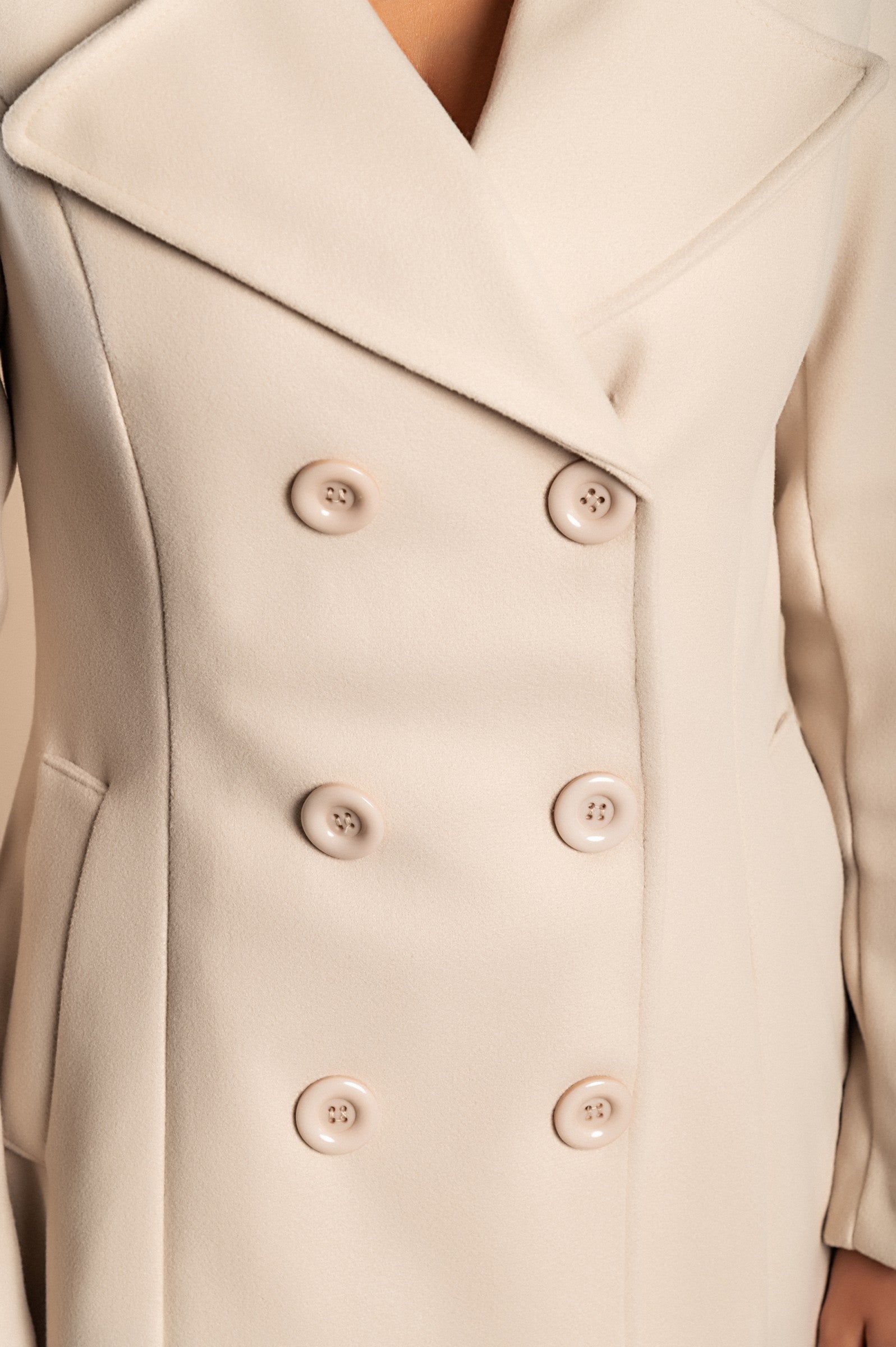 Elegant beige coat with buttons, featuring a classic collar and side pockets, made from high-quality polyester fabric.