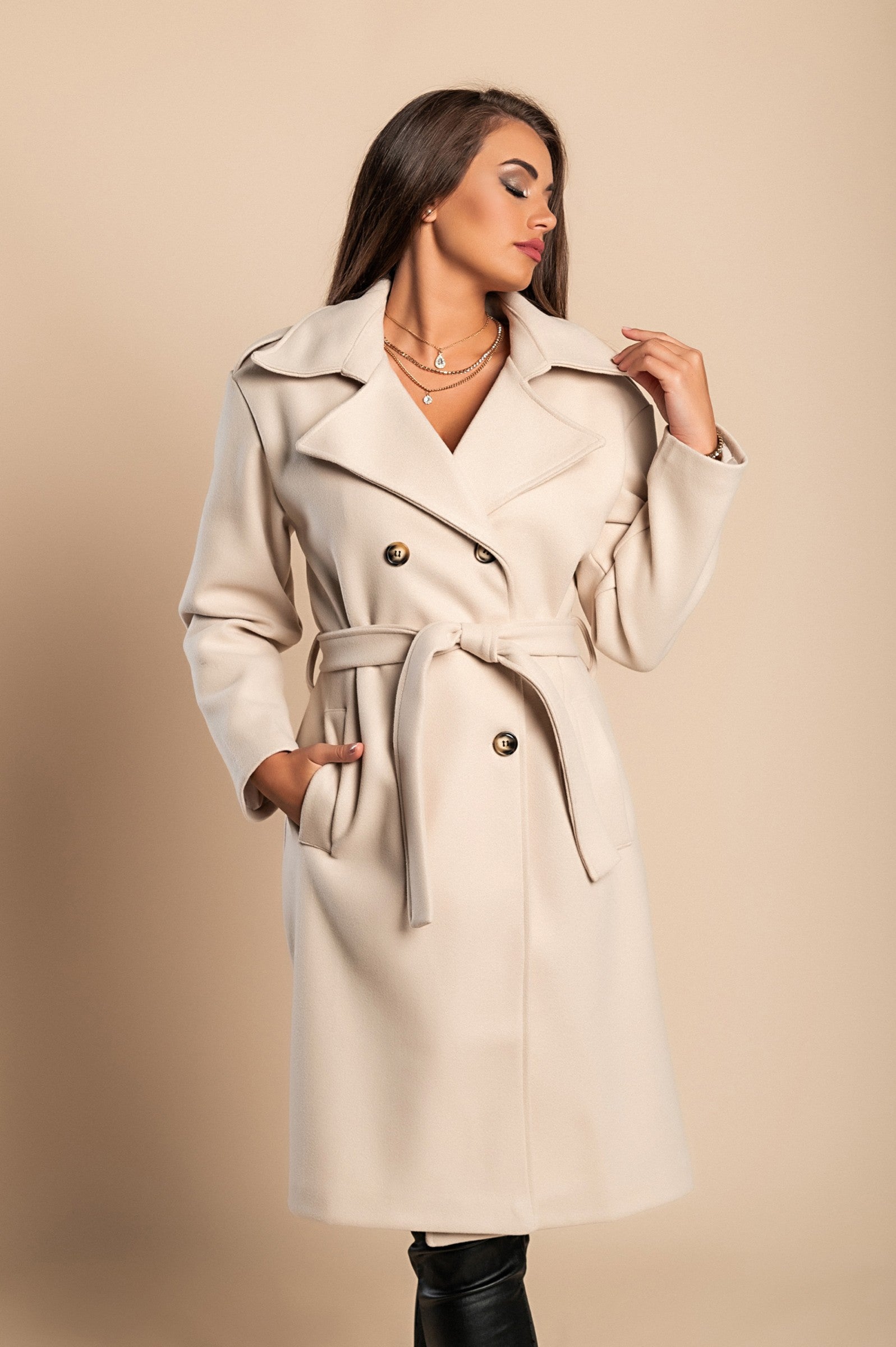 Elegant beige coat with buttons, featuring a classic collar, decorative belt, and knee-length design, made from high-quality soft fabric.