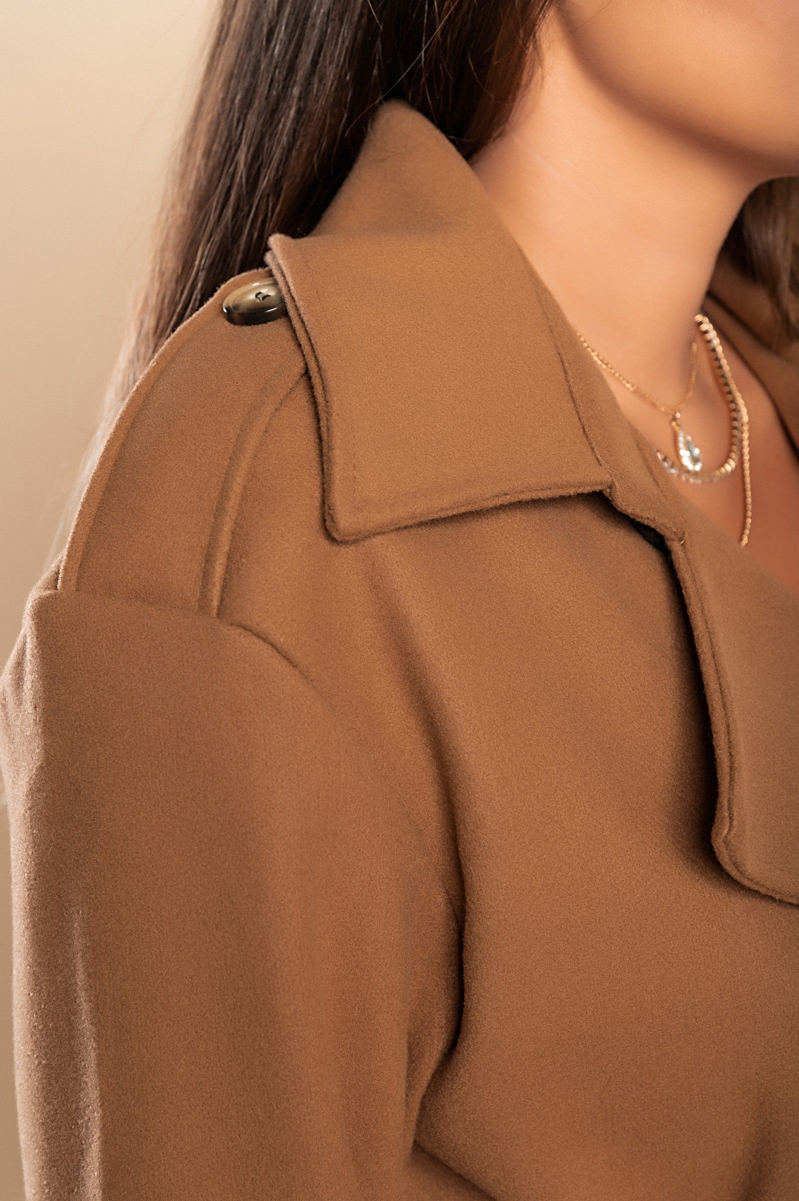 Elegant camel coat with buttons, featuring a classic collar and decorative belt, knee-length design with side pockets.