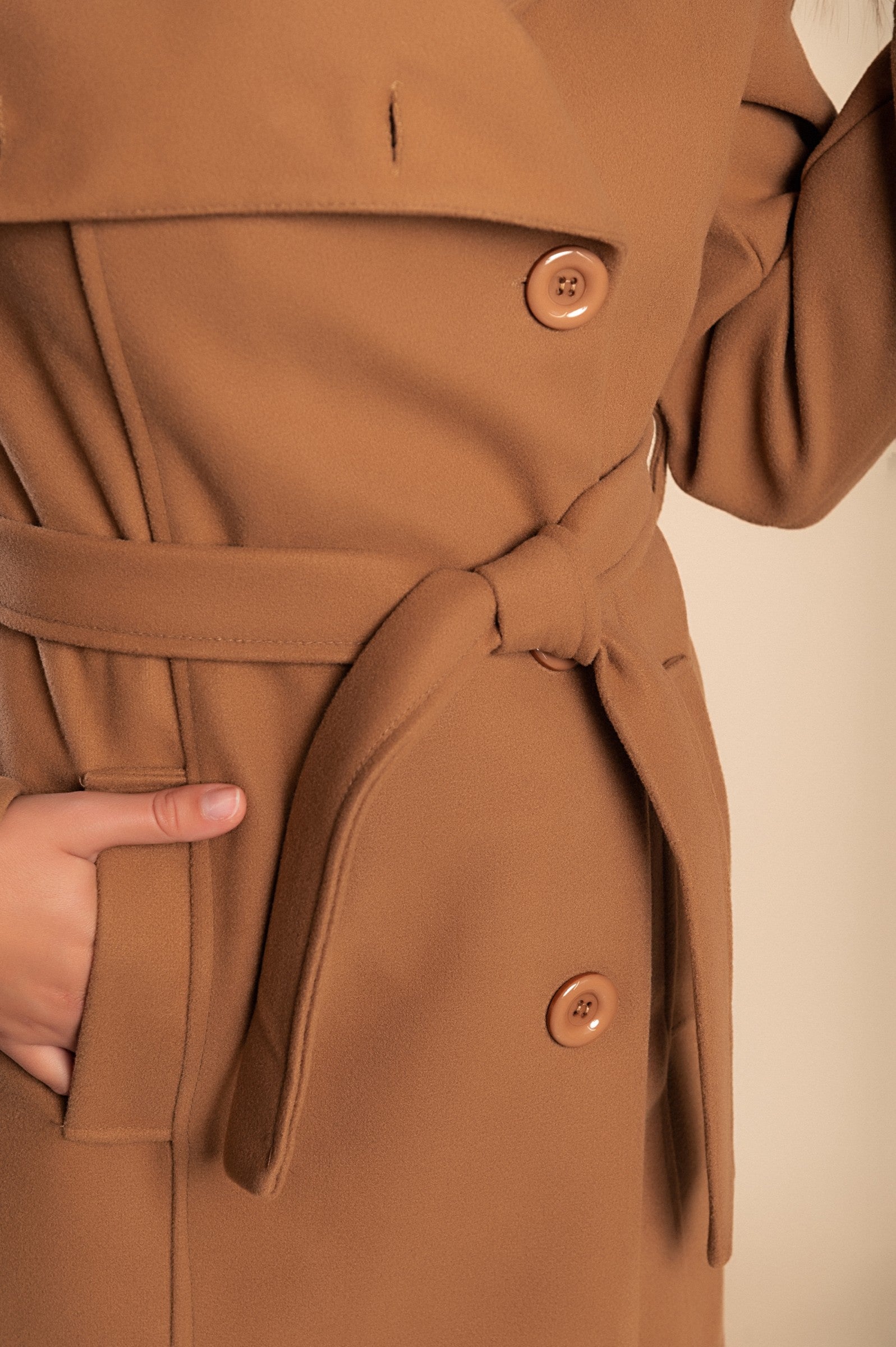 Elegant camel coat with buttons, featuring a high collar, long sleeves, and decorative belt, perfect for stylish layering.