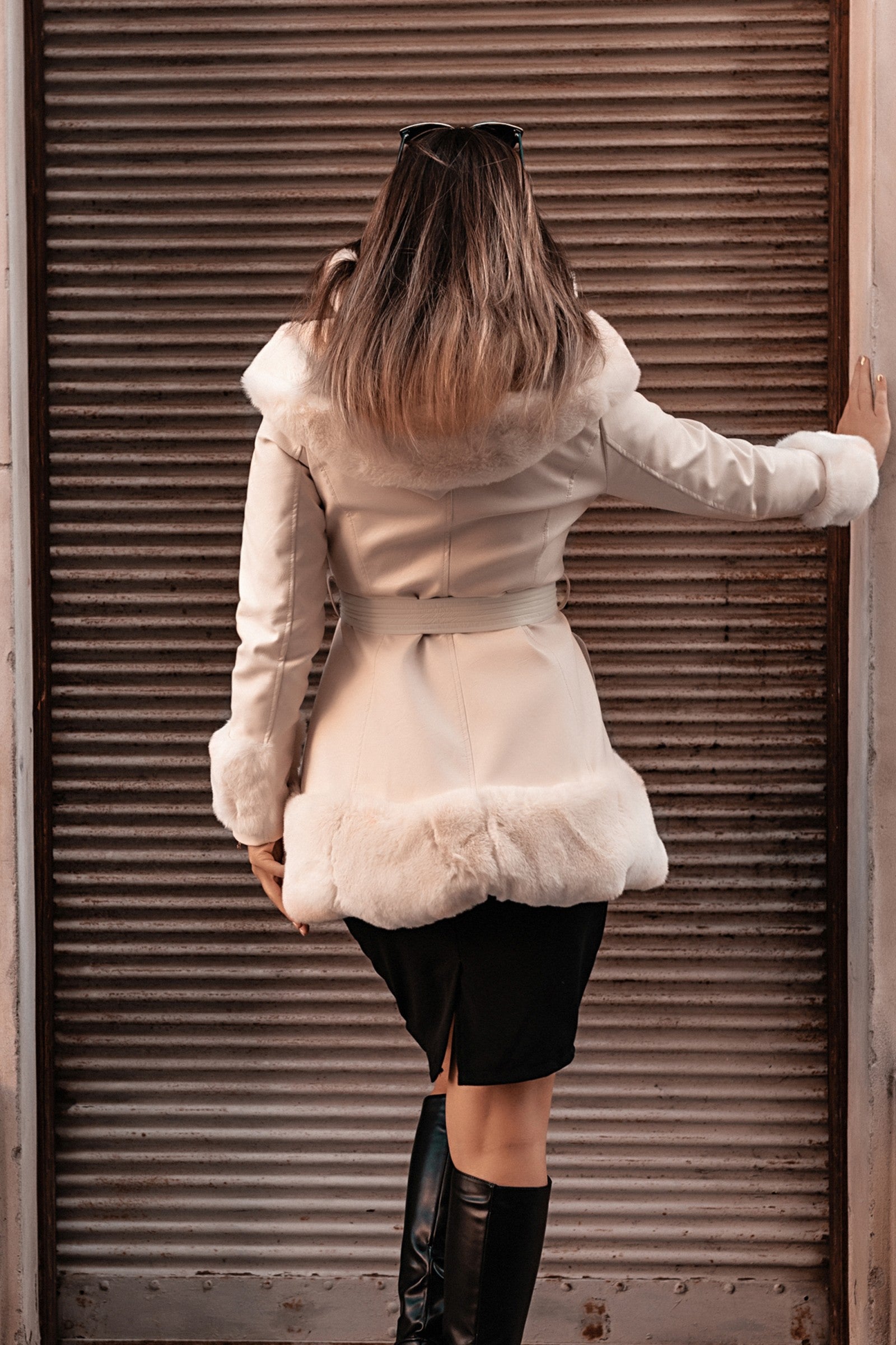 Elegant white coat with faux fur hood and details, featuring a full zip closure and front pockets.