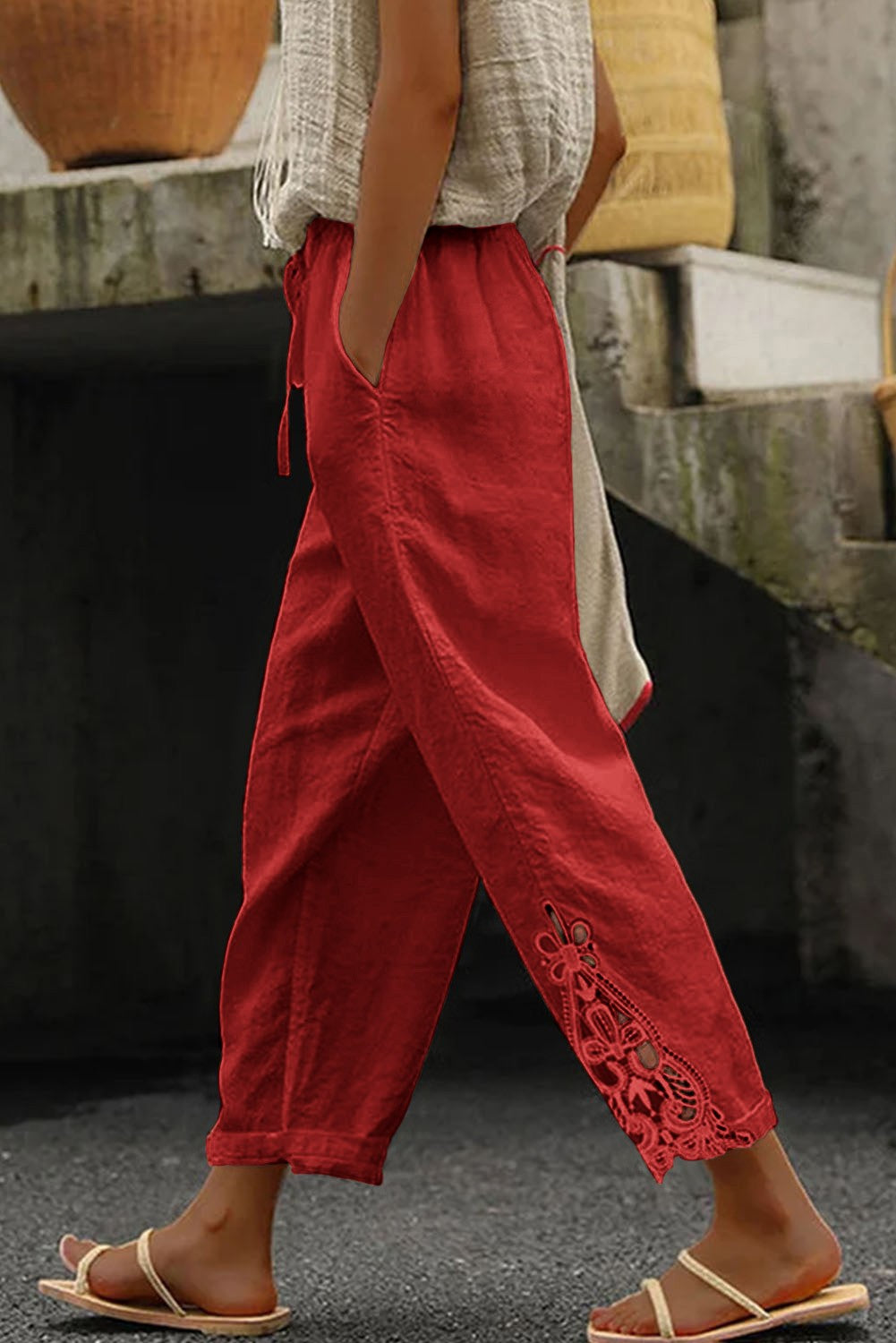 Elegant red cotton trousers with lace detailing, featuring an elastic and drawstring waist.