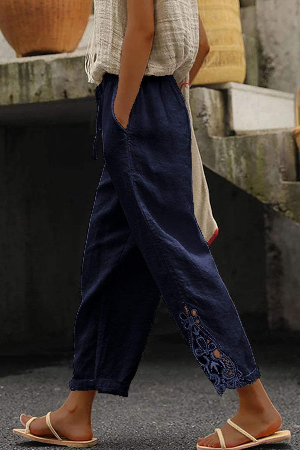 Elegant dark blue cotton trousers with lace trim, featuring an elastic and drawstring waist, designed for comfort and style.