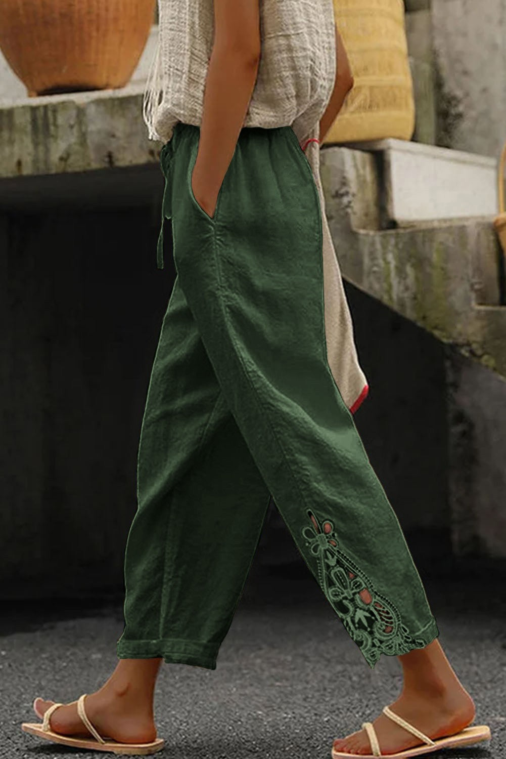 Elegant olive green cotton trousers with lace trim, featuring an elastic and drawstring waist, designed for comfort and style.