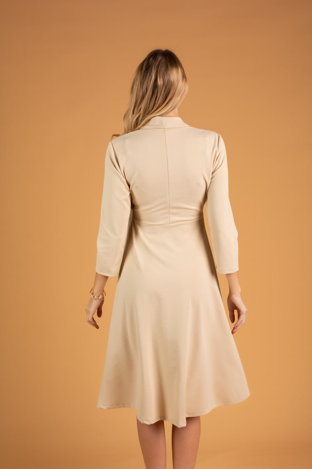 Elegant beige dress with a folding collar and 3/4 sleeves, featuring a deep V neckline and a loose mid-thigh skirt.