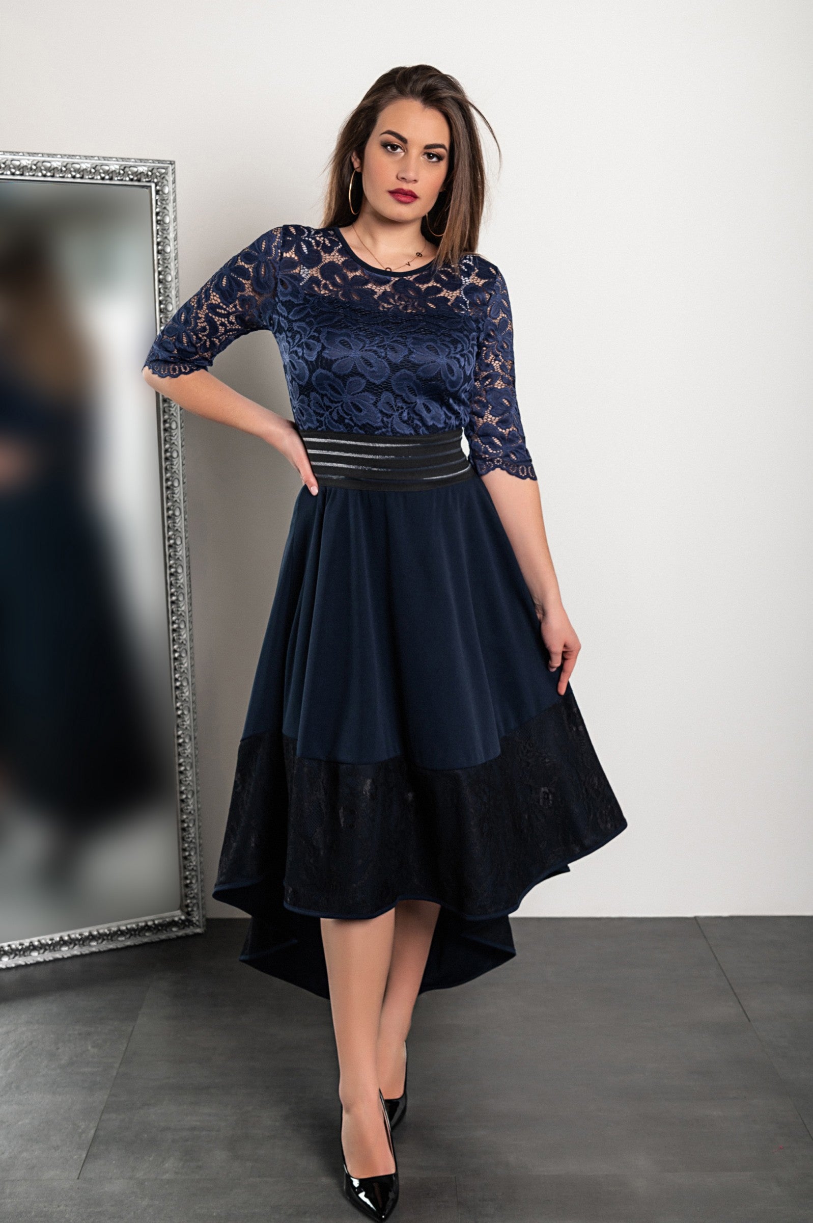 Elegant dark blue dress with lace detailing, featuring sheer 3/4 sleeves and an asymmetrical skirt.