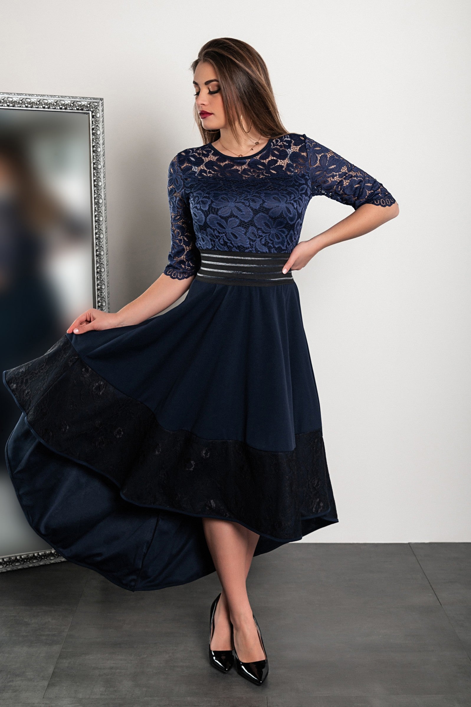 Elegant dark blue lace dress Bianca with asymmetrical design and sheer 3/4 sleeves, featuring a tight waist and lace detailing.