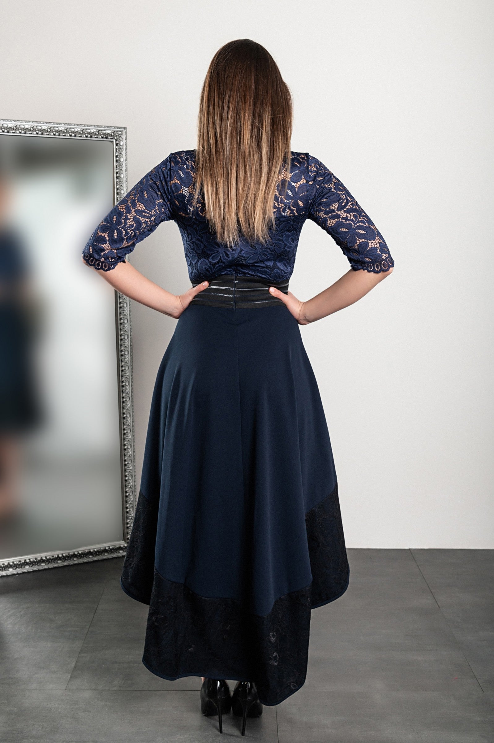 Elegant dark blue lace dress Bianca with asymmetrical design and sheer 3/4 sleeves, featuring a tight waist and lace detailing.