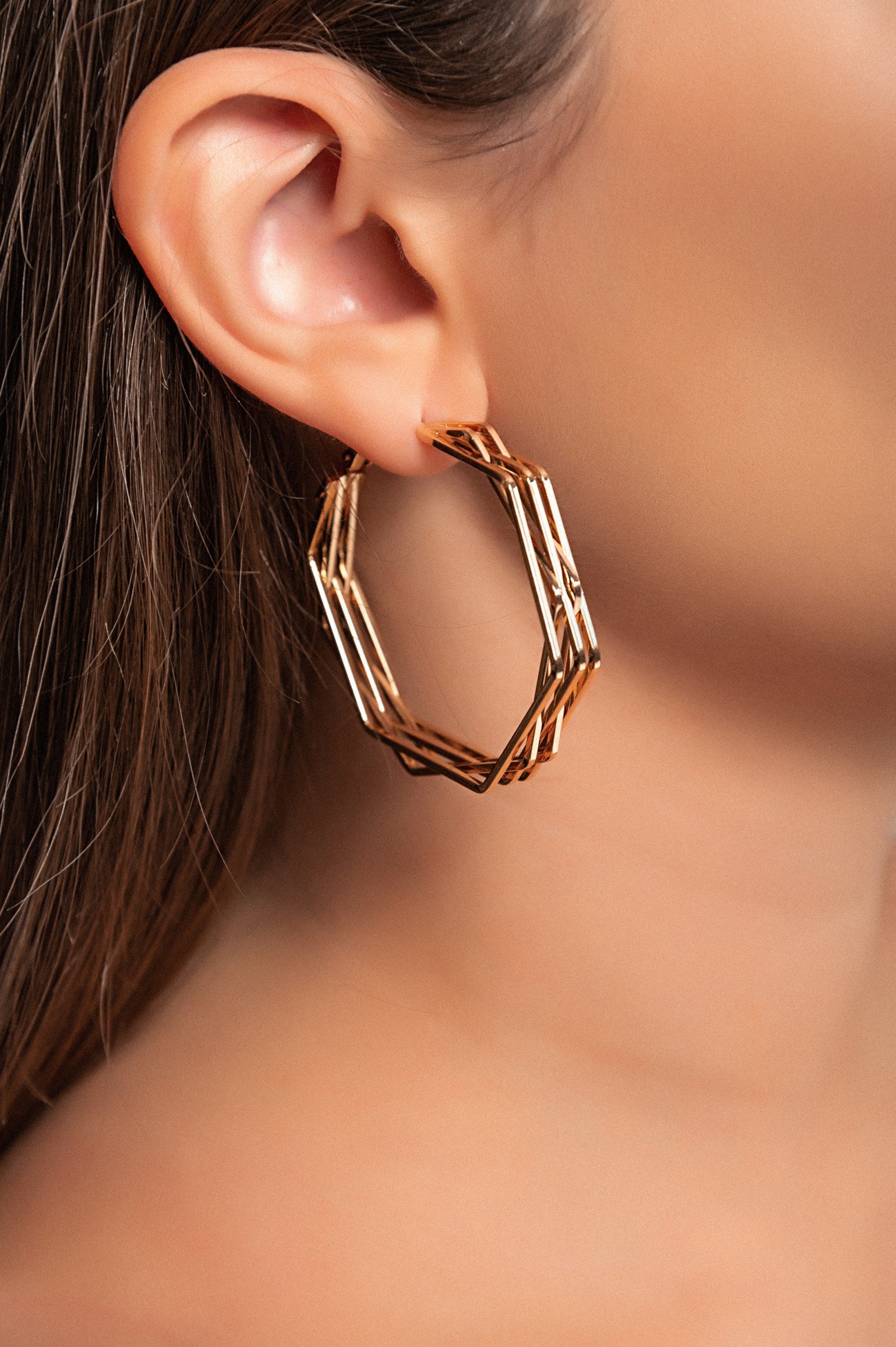 Elegant gold earrings in a unique hexagonal shape, crafted from 100% brass, perfect for enhancing any outfit.