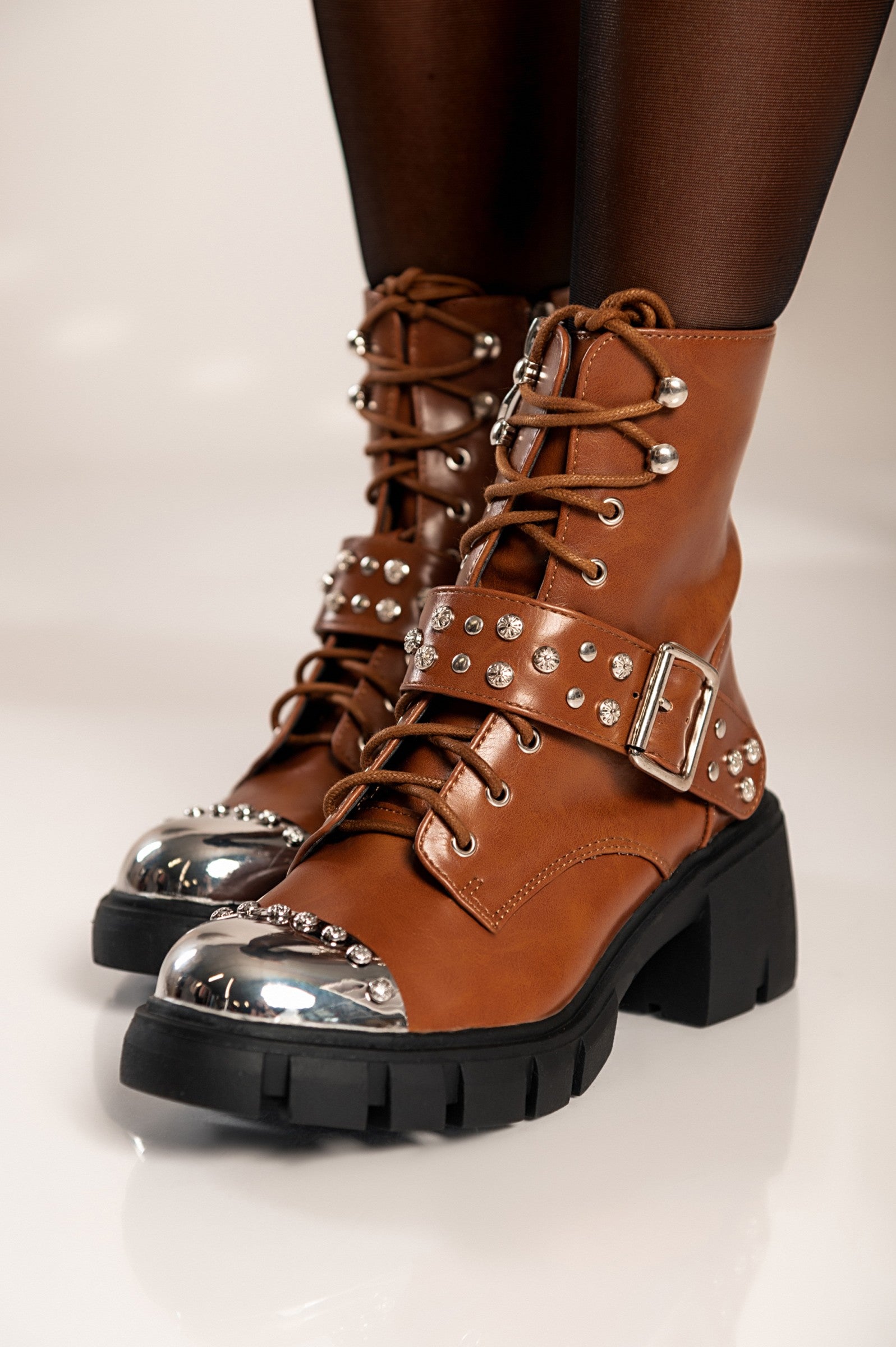 Elegant brown heeled ankle boots Coria with round toe, metal cap detail, and bows, showcasing high-quality artificial leather.