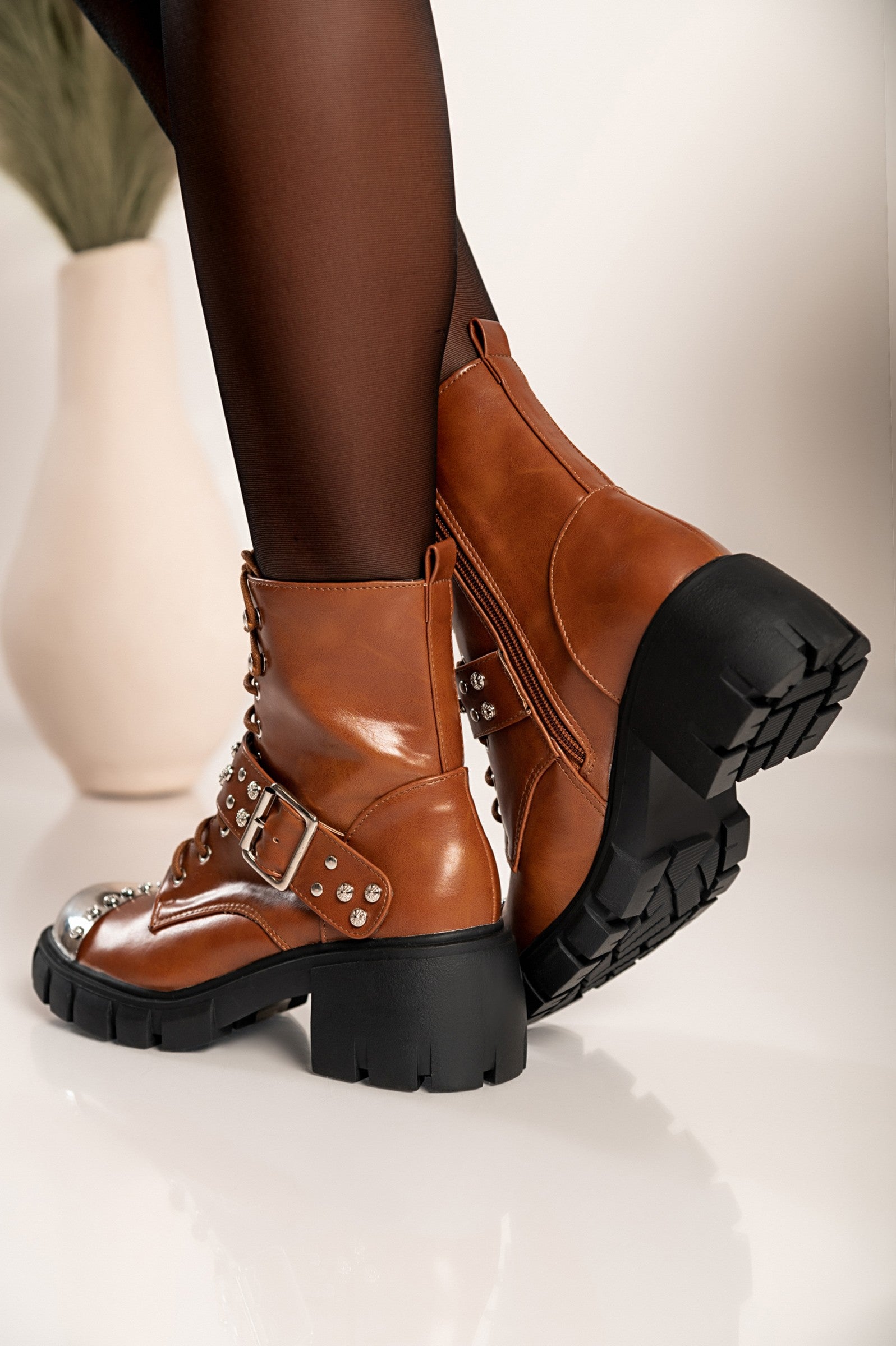 Elegant brown heeled ankle boots Coria with round toe, metal cap detail, and bows, showcasing high-quality artificial leather.