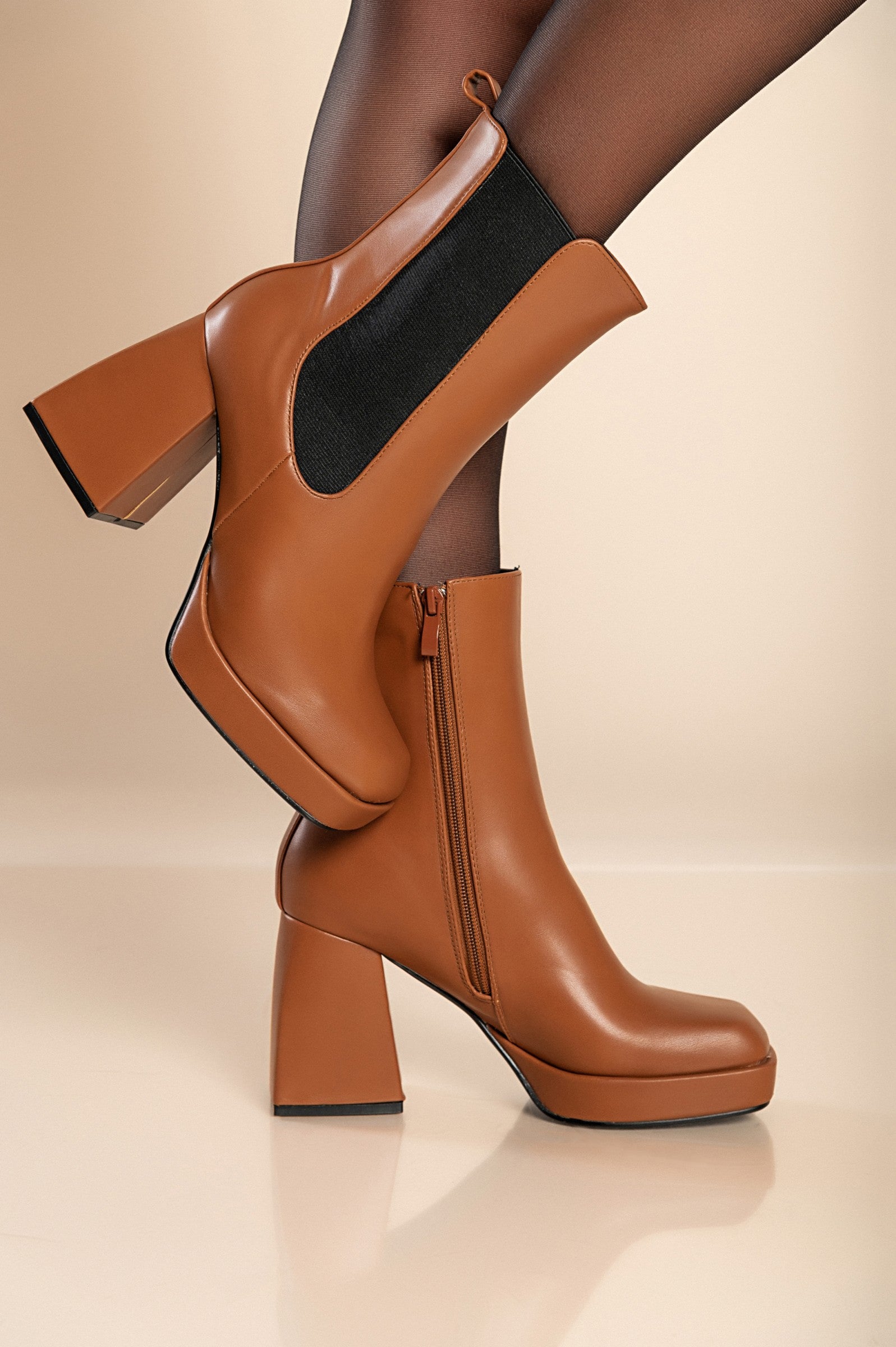 Elegant high-heeled ankle boots in camel color with square toe and interior zipper closure.