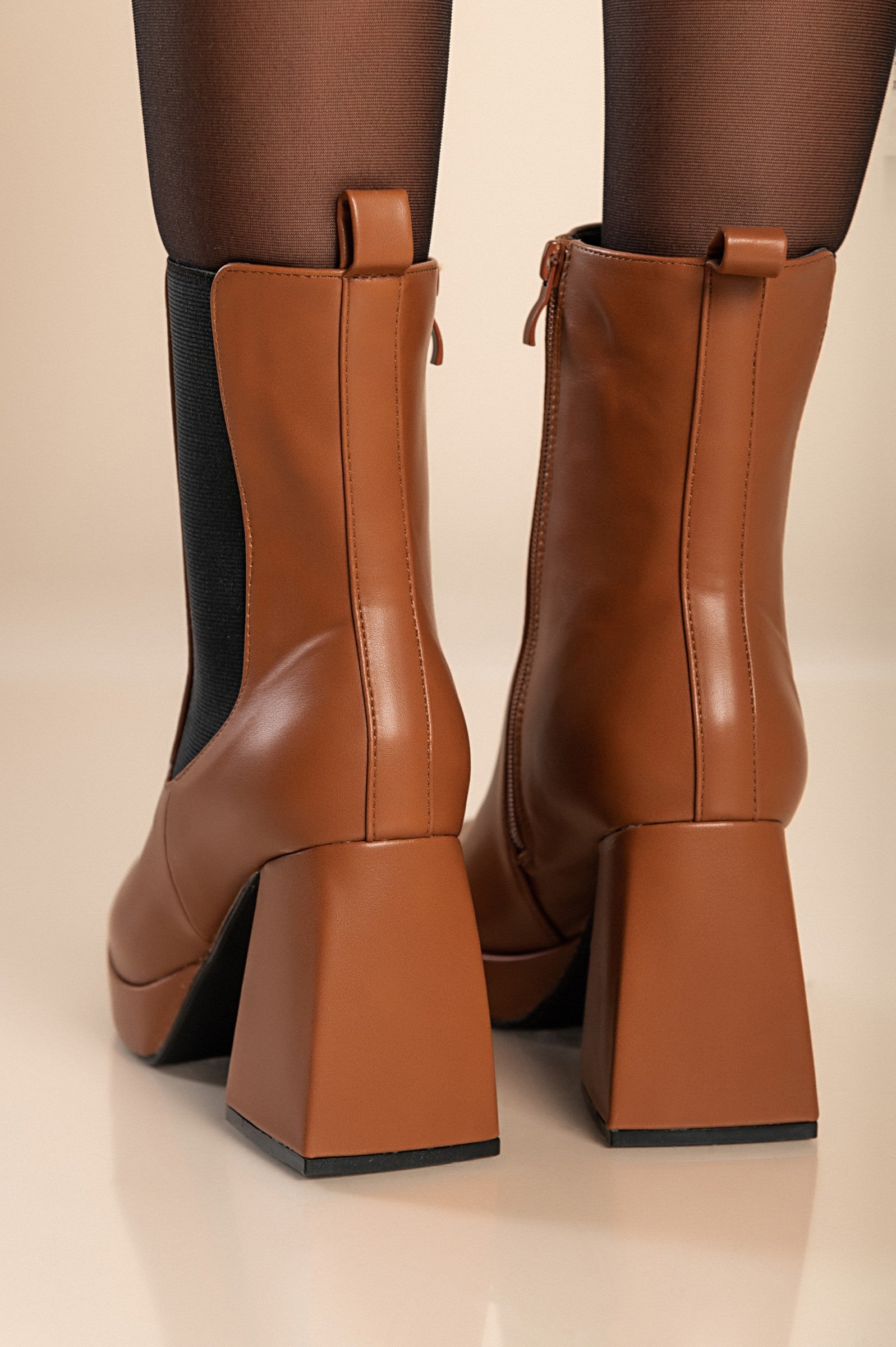 Elegant high-heeled ankle boots in camel color with square toe and interior zipper closure, made from high-quality faux leather.