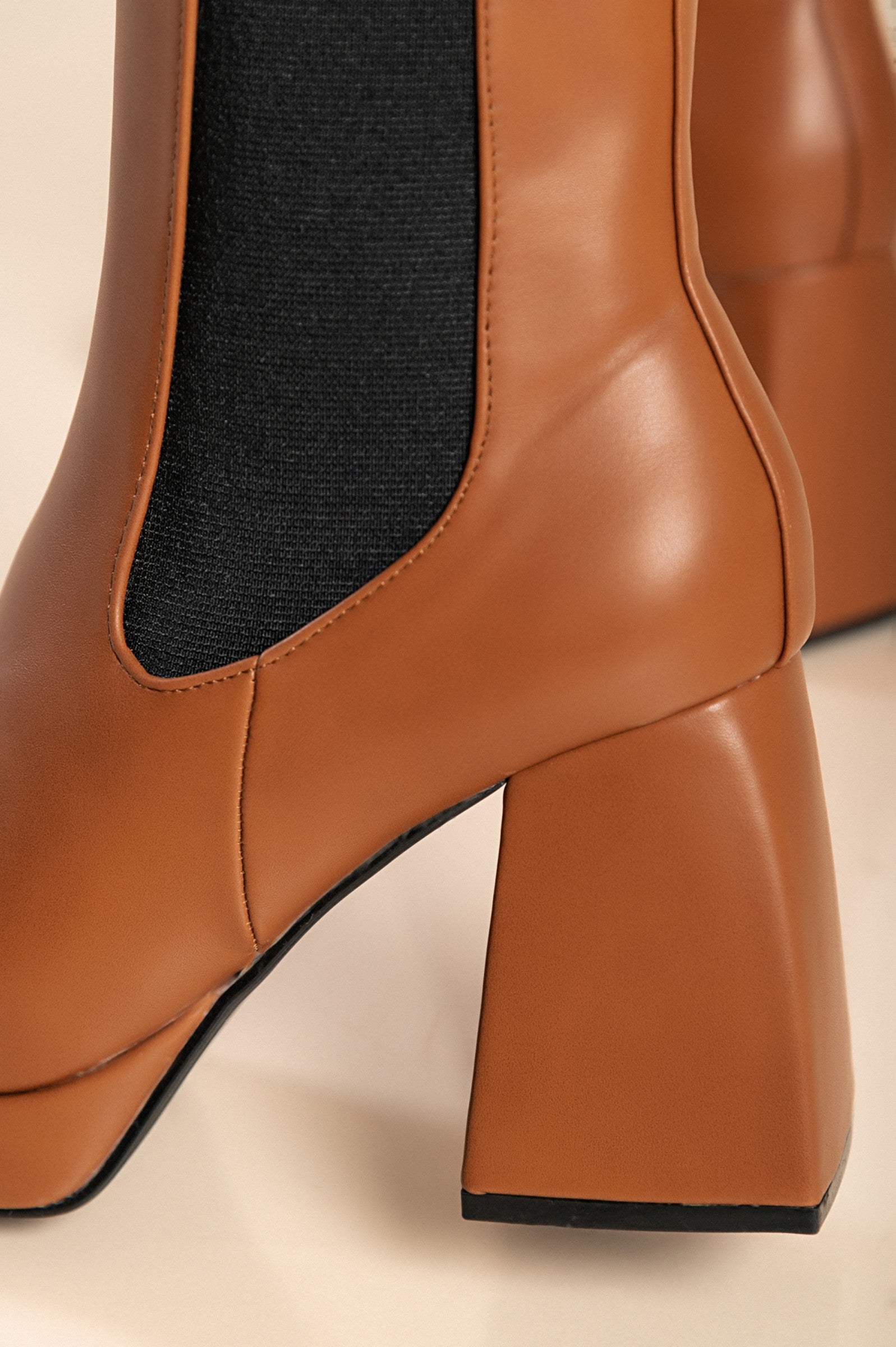 Elegant high-heeled ankle boots in camel color with square toe and interior zipper closure, made from high-quality faux leather.