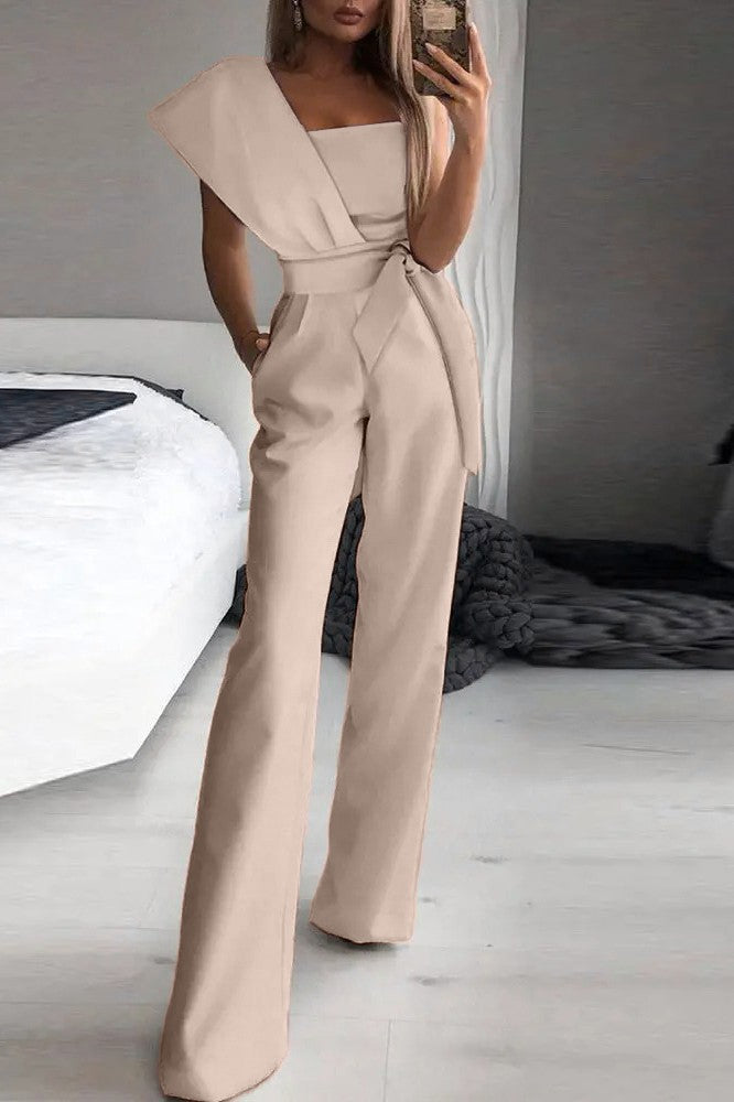 Elegant beige jumpsuit Chia featuring an asymmetrical neckline and one sleeve, made from high-quality fabric.