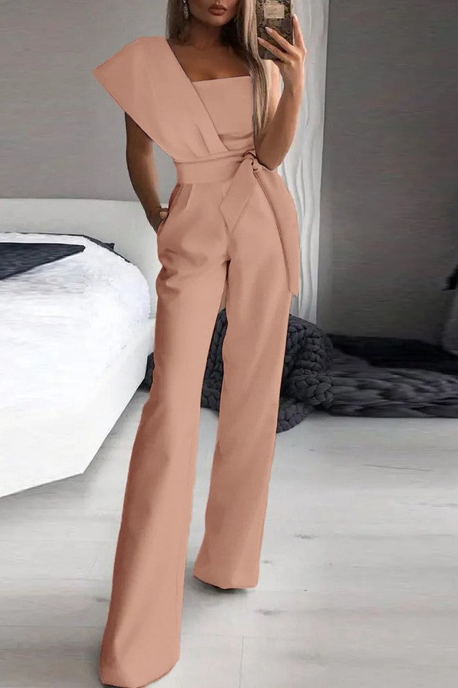 Elegant pink jumpsuit Chia with asymmetric neckline and one sleeve, featuring long wide pants and a stylish belt.