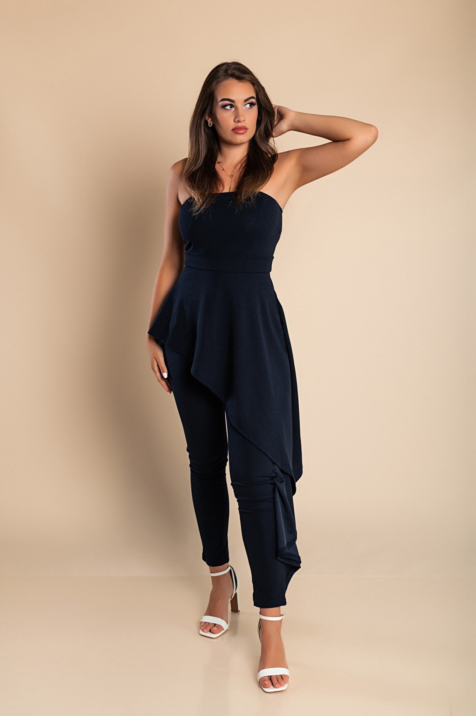 Elegant dark blue jumpsuit Ema with asymmetric skirt detail and zipper closure, showcasing Italian craftsmanship.