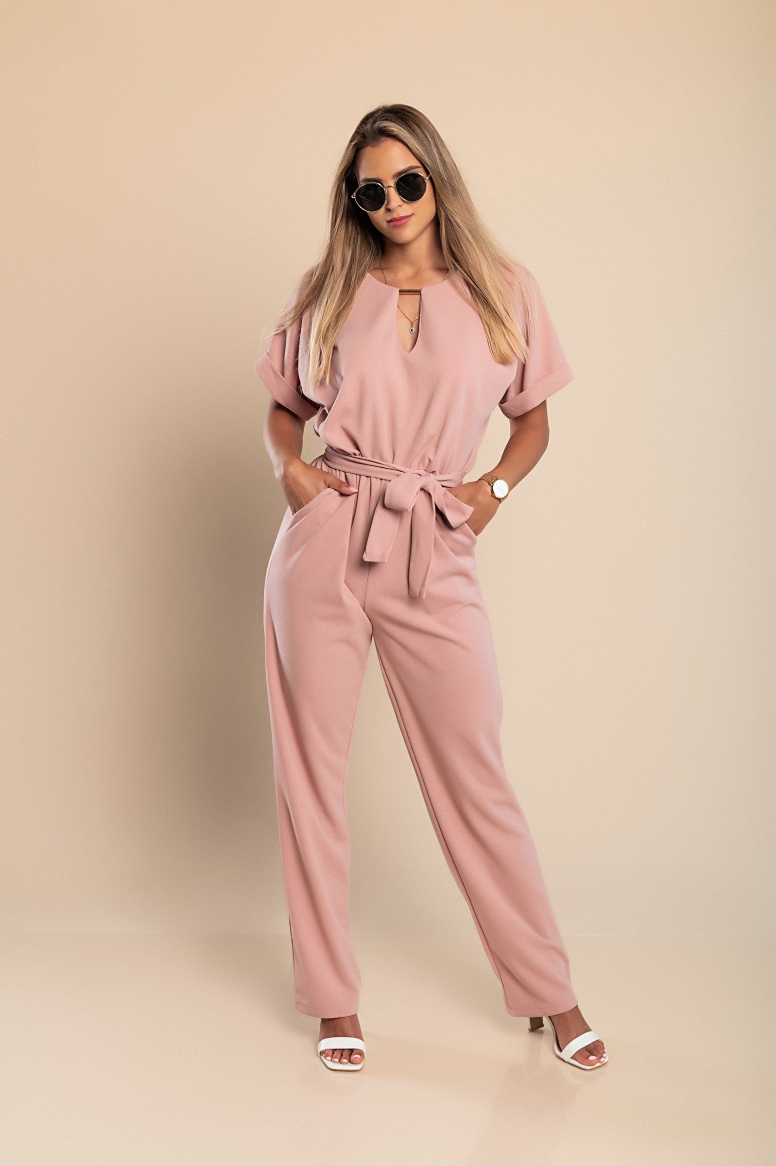 Elegant light pink jumpsuit featuring metallic detail and plunging neckline, perfect for stylish occasions.