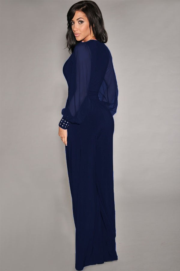 Elegant dark blue jumpsuit with 'V' neckline and translucent long sleeves, featuring fashionable wrist accessories.