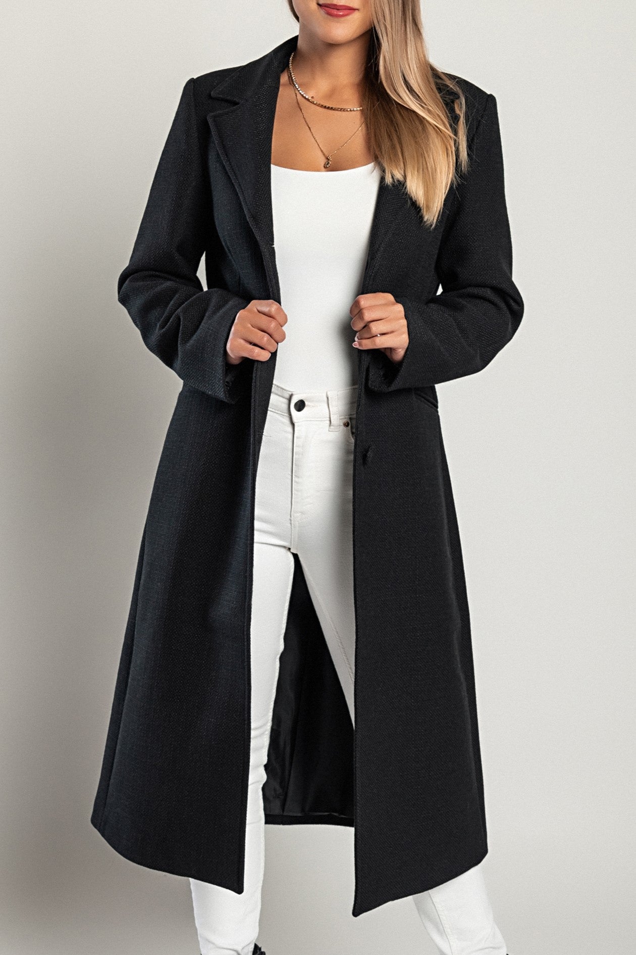 Elegant long black coat with classic collar and button closure, featuring side pockets and made in Italy.