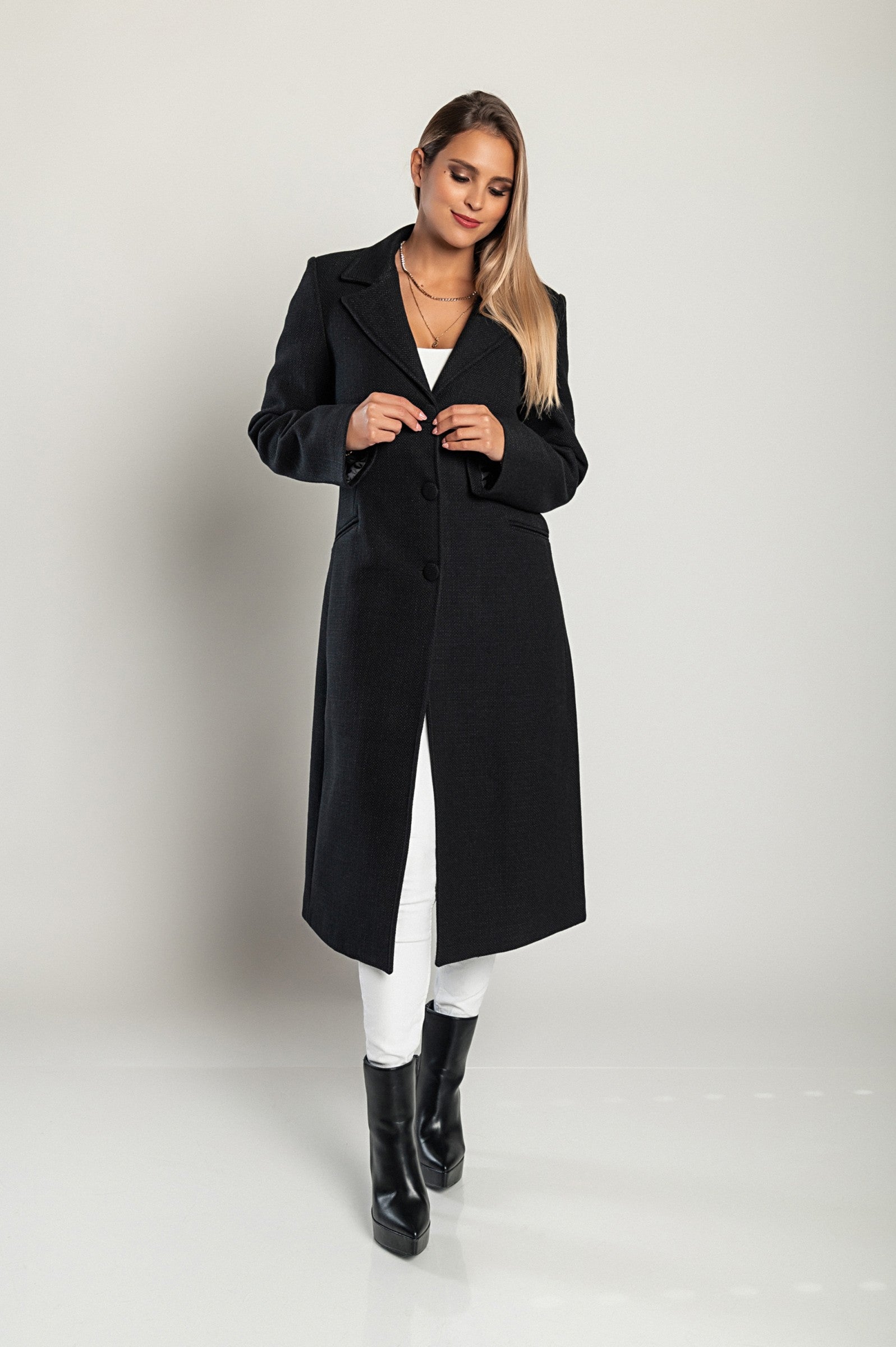 Elegant long black coat with classic collar and button closure, featuring side pockets and long sleeves, made in Italy.