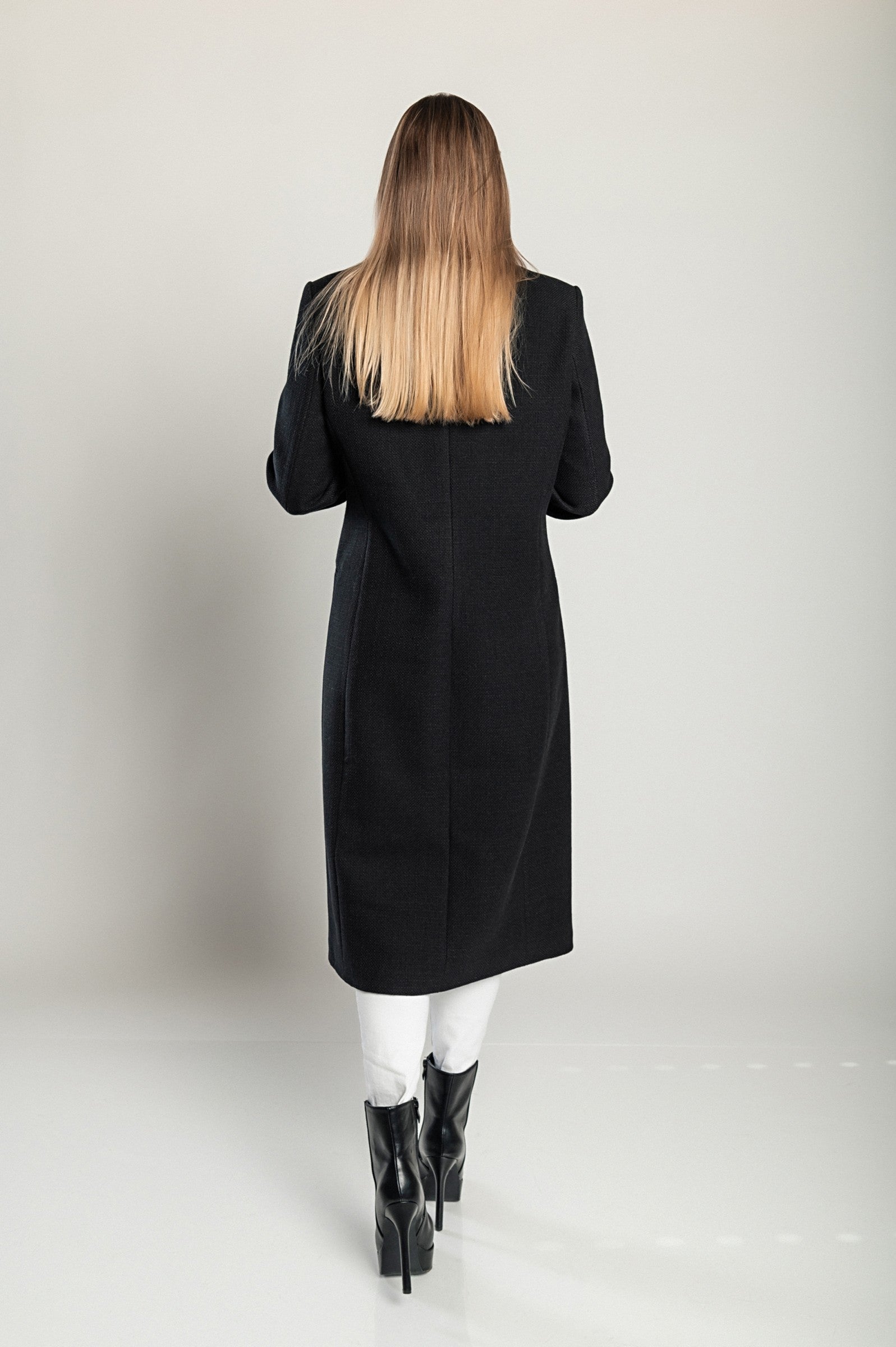 Elegant long black coat with classic collar and button closure, featuring side pockets and long sleeves, made in Italy.