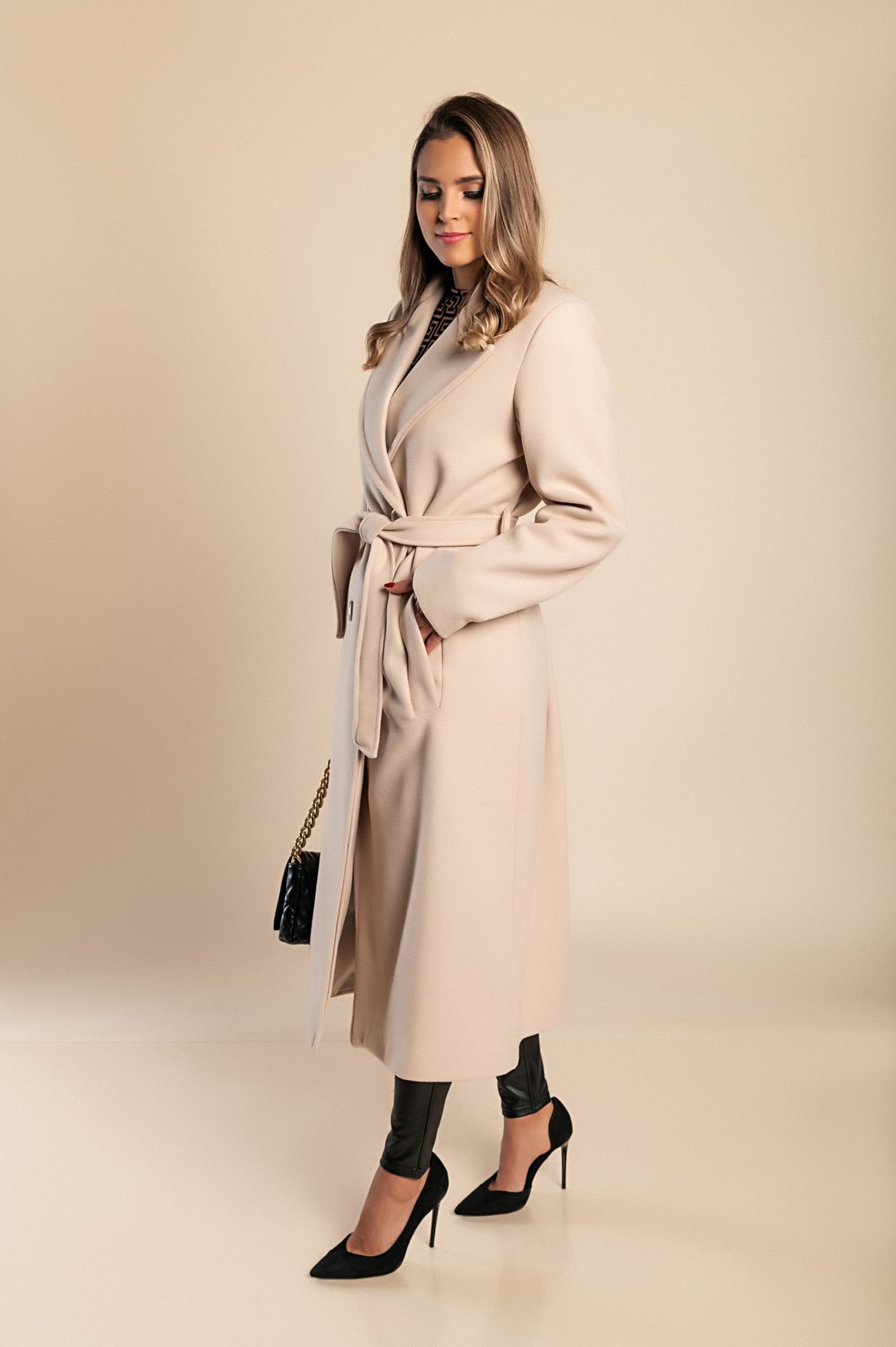 Elegant long beige coat with buttons, featuring a classic collar and decorative belt, made from high-quality soft fabric.