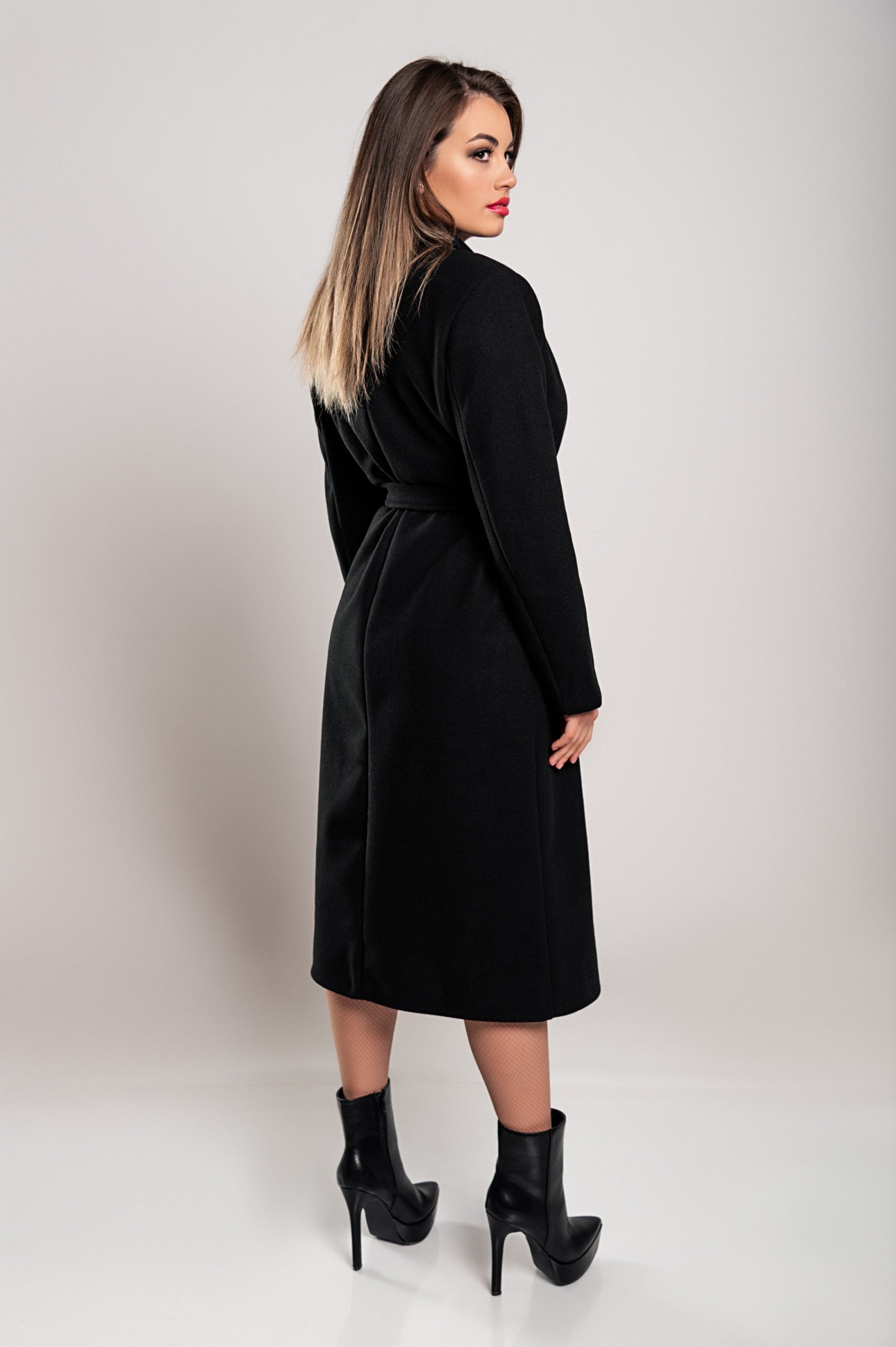 Elegant black long coat with buttons and decorative belt, showcasing classic collar and long sleeves.