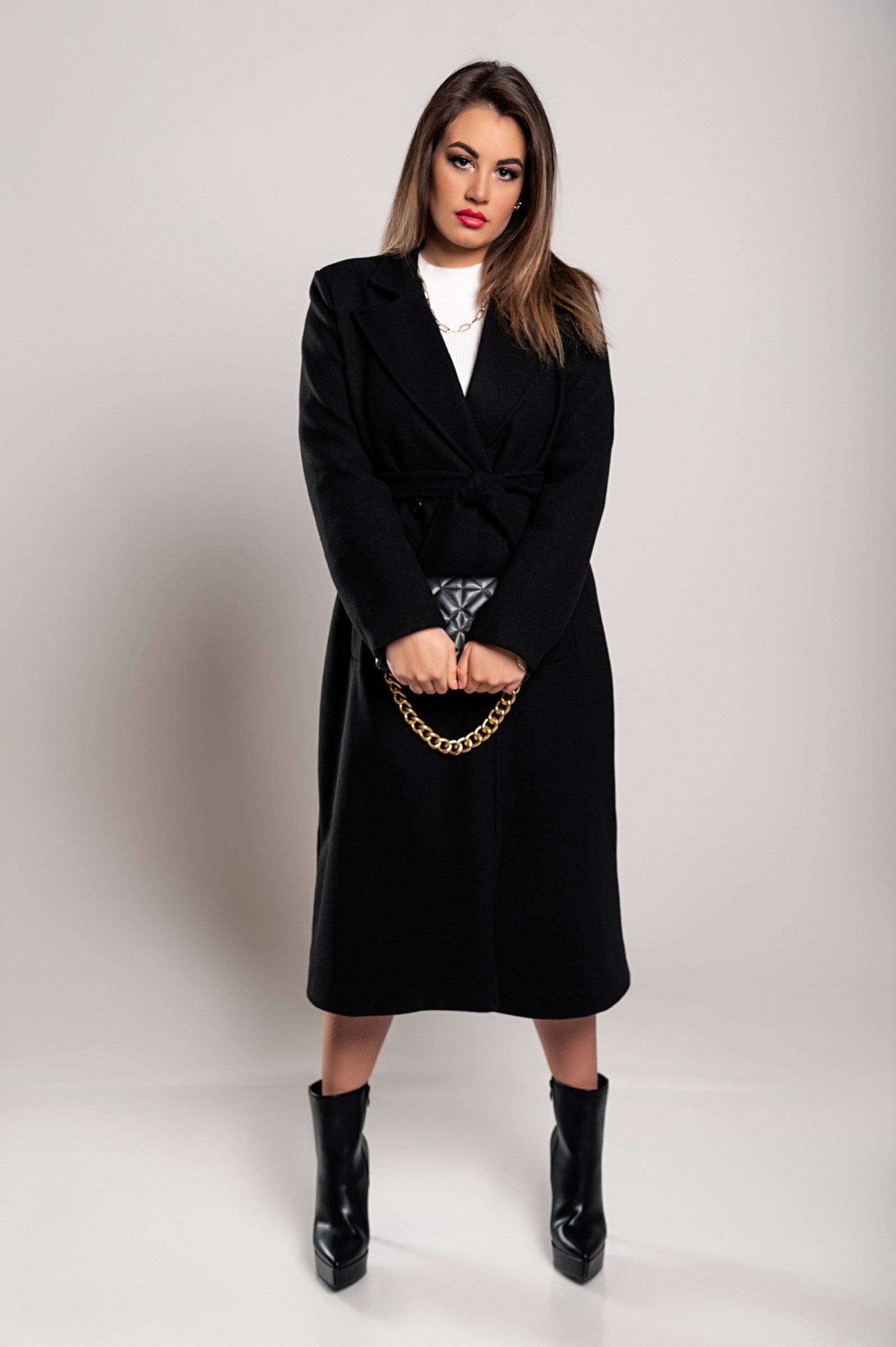 Elegant black long coat with buttons and decorative belt, showcasing classic collar and long sleeves.