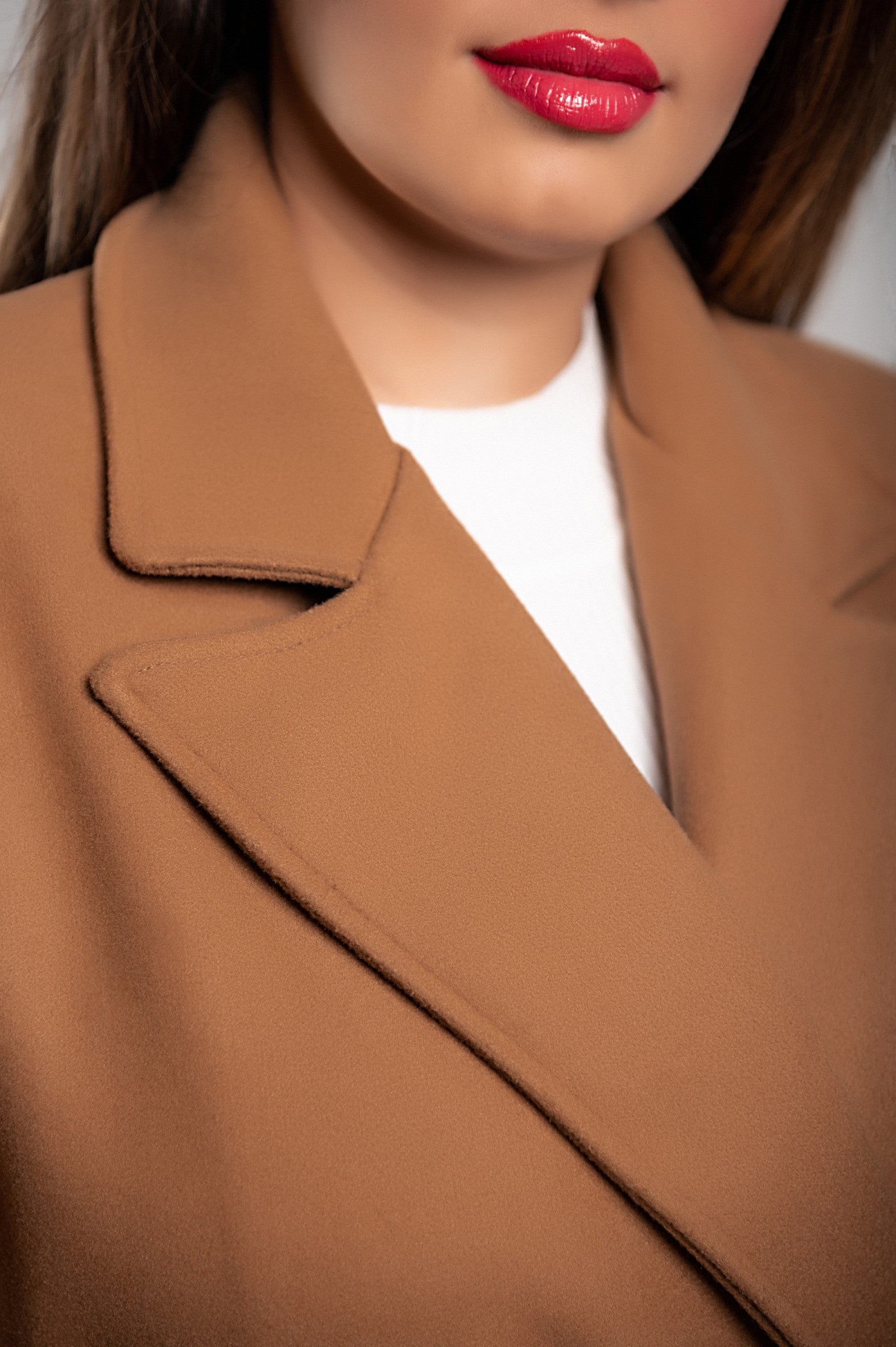 Elegant camel long coat with buttons, featuring a classic collar and decorative belt, perfect for stylish occasions.