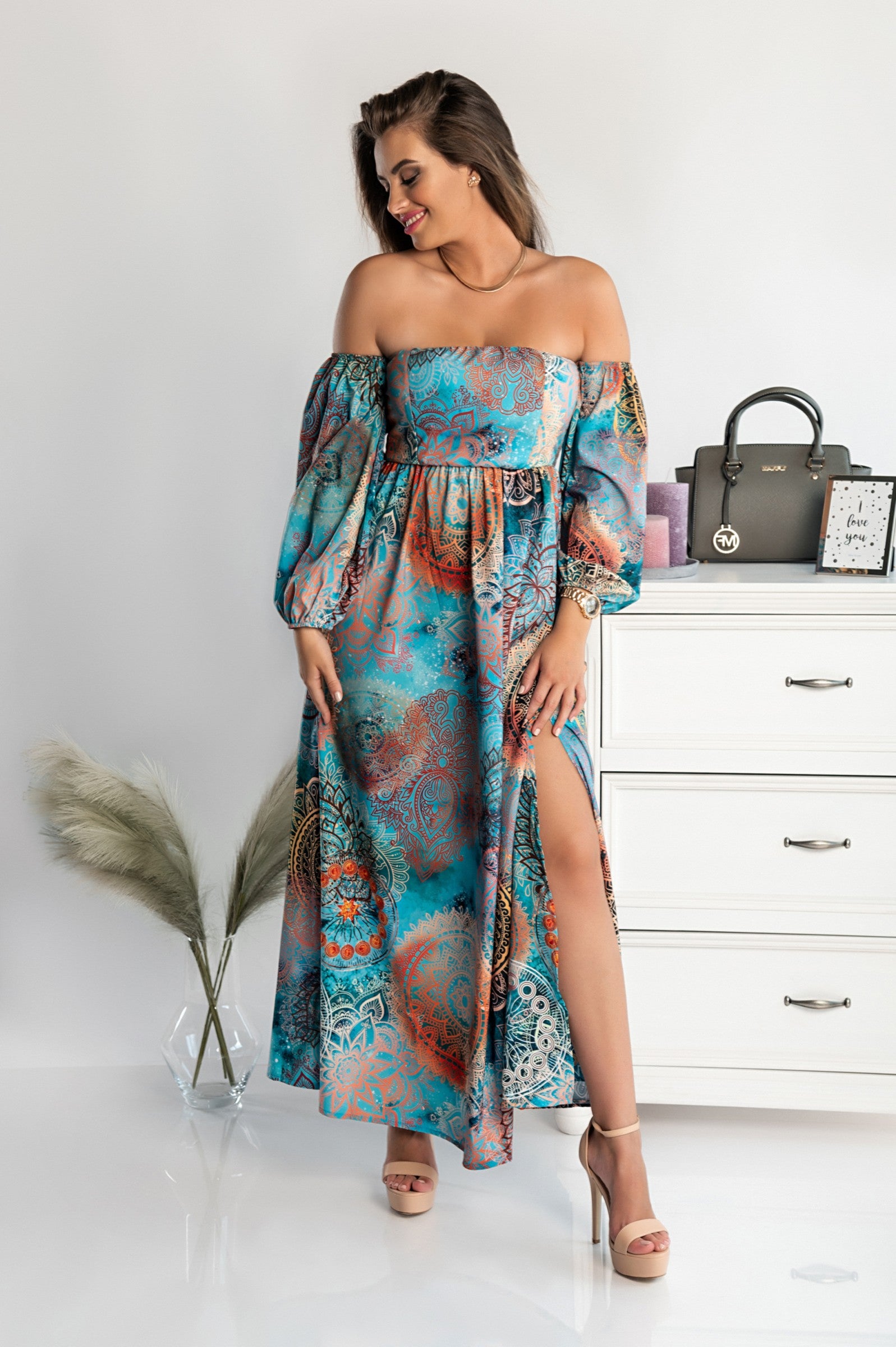 Elegant light blue maxi dress with print Montella featuring long sleeves, straight neckline, and a loose cut skirt with a front opening.