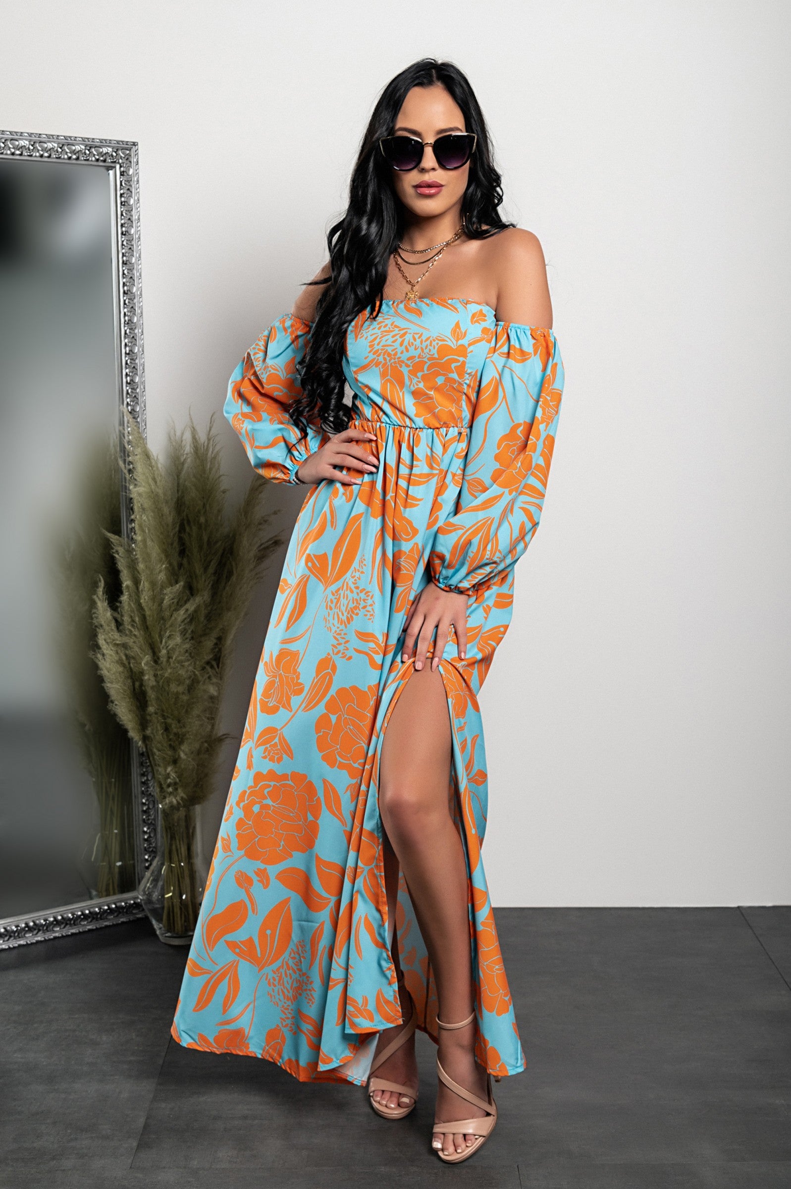 Elegant orange maxi dress with print, featuring long sleeves and a straight neckline, designed for comfort and style.