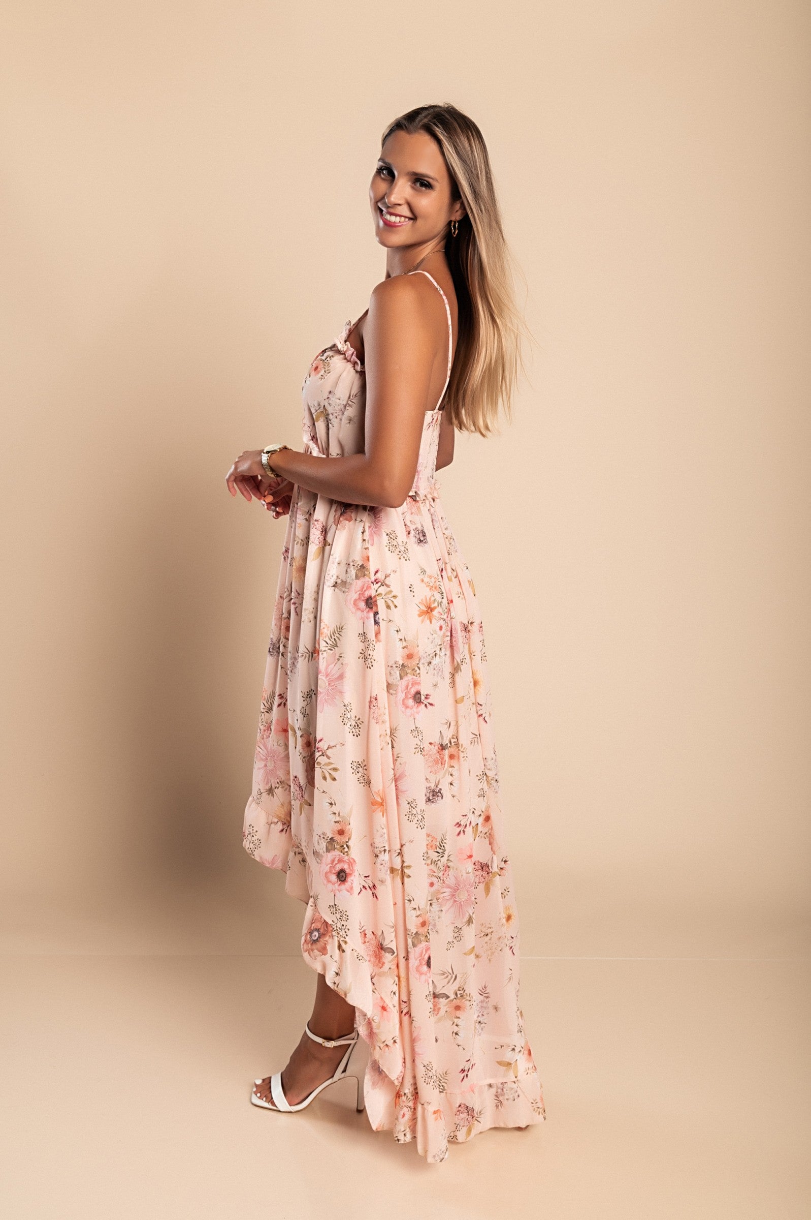 Elegant beige maxi dress with print featuring a plunging neckline, ruffle trim, and asymmetrical skirt with ruffles, designed for comfort and style.