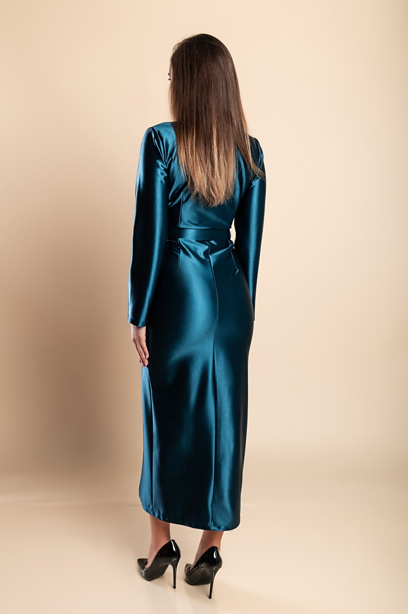 Elegant petrol midi dress made of imitation satin with deep neckline and long sleeves, featuring a decorative belt and stylish skirt opening.