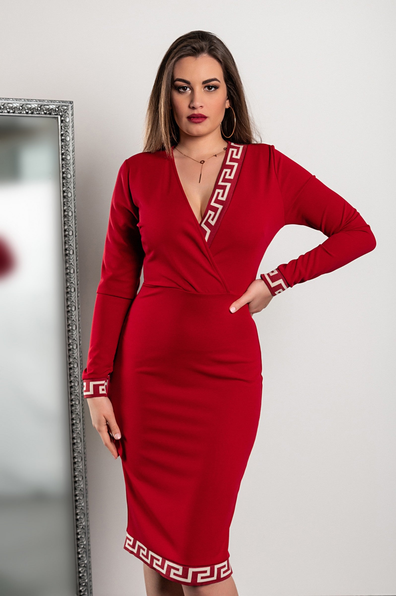 Elegant burgundy midi dress featuring a geometric print, fitted cut, deep neckline, and long sleeves, reaching knee length.