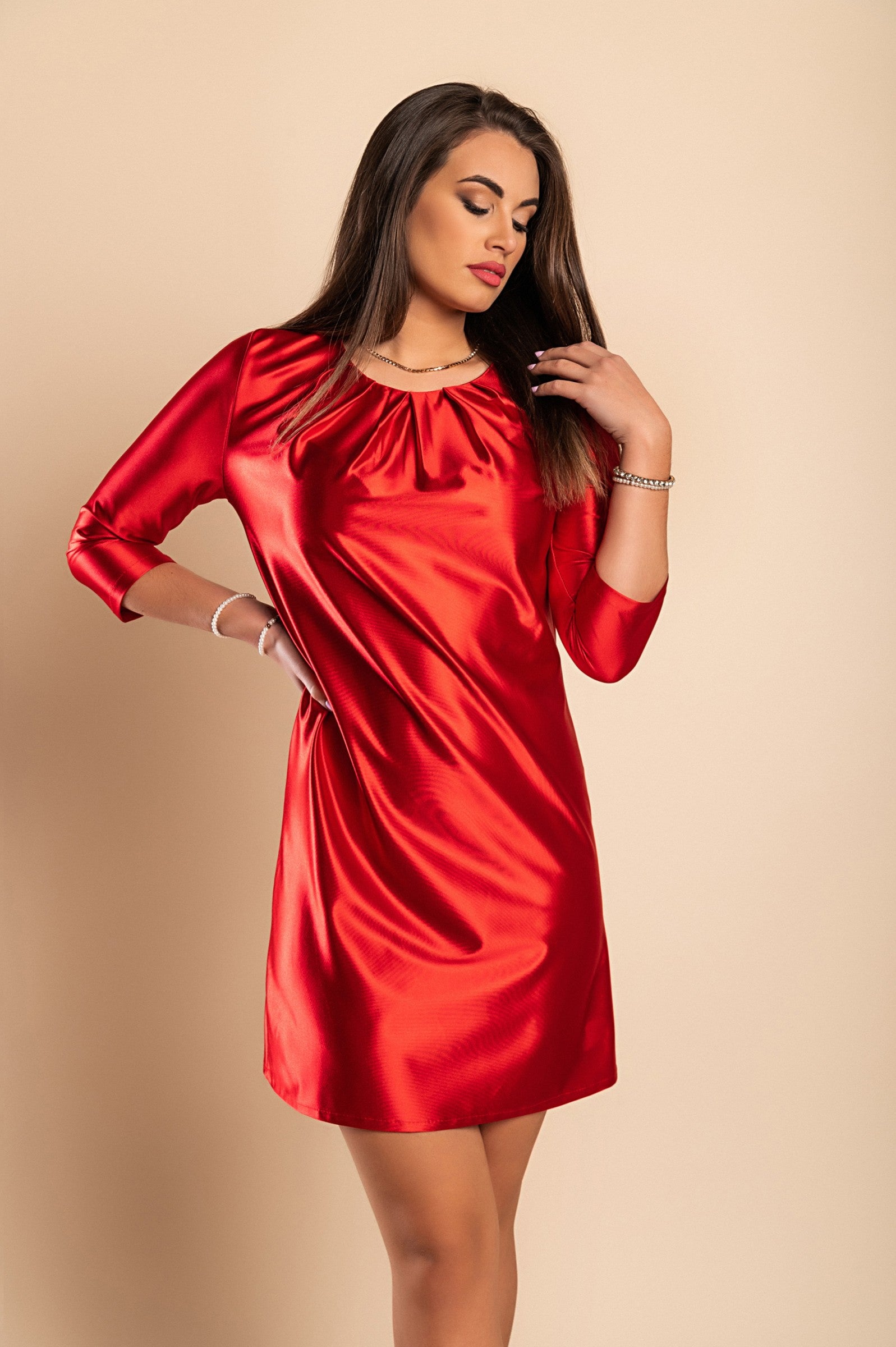 Elegant red mini dress made of imitation satin with round neckline and 3/4 sleeves, showcasing a loose fit and mid-thigh length.