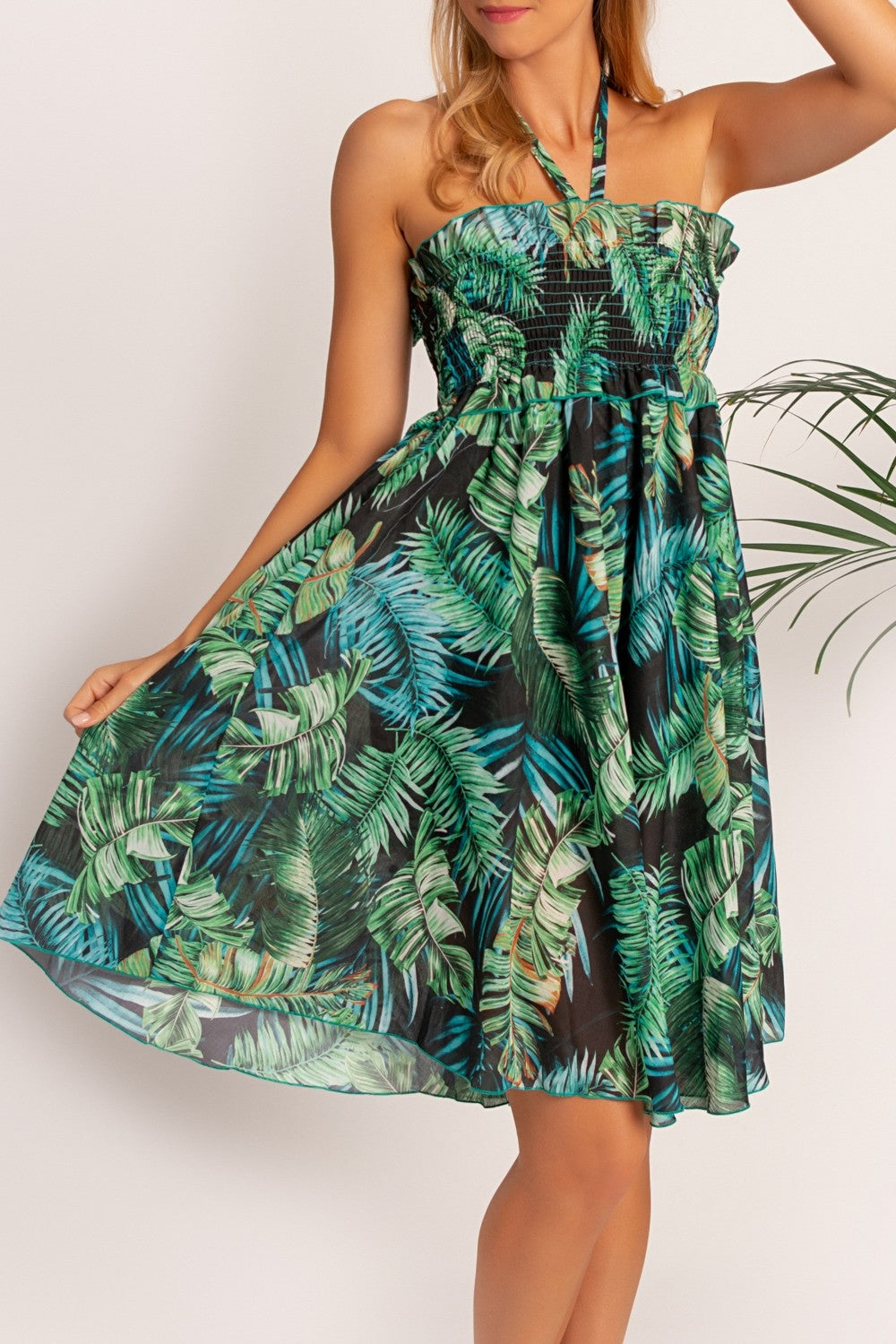 Elegant green mini dress with tropical print, featuring an elastic top and loose skirt, designed for comfort and style.