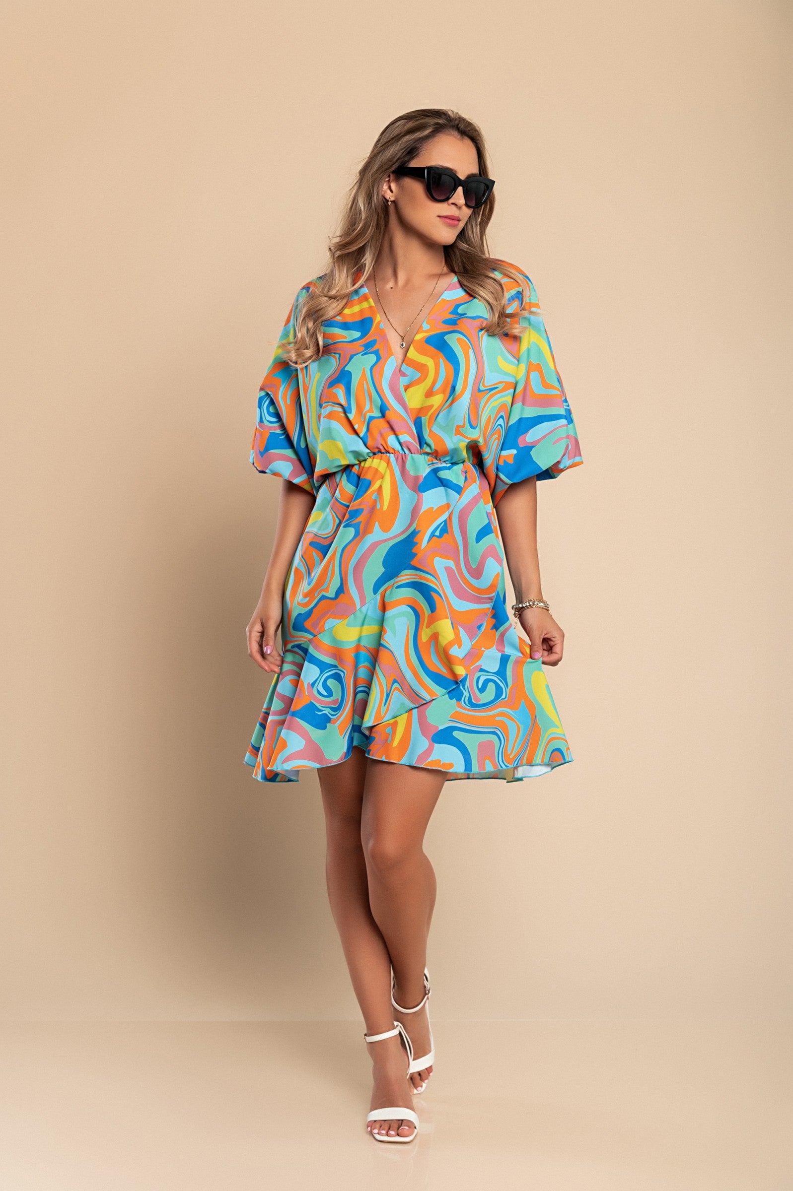 Elegant turquoise mini dress with print, featuring a deep neckline, short sleeves, and a decorative belt, designed for comfort and style.