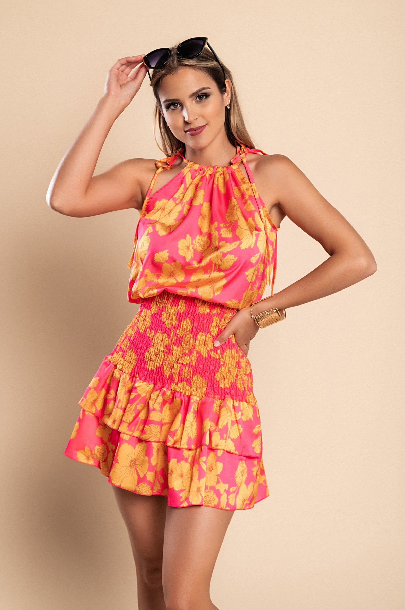 Elegant fuchsia mini dress with print, featuring a round neckline, thin shoulder straps, and a ruffled mid-thigh skirt.