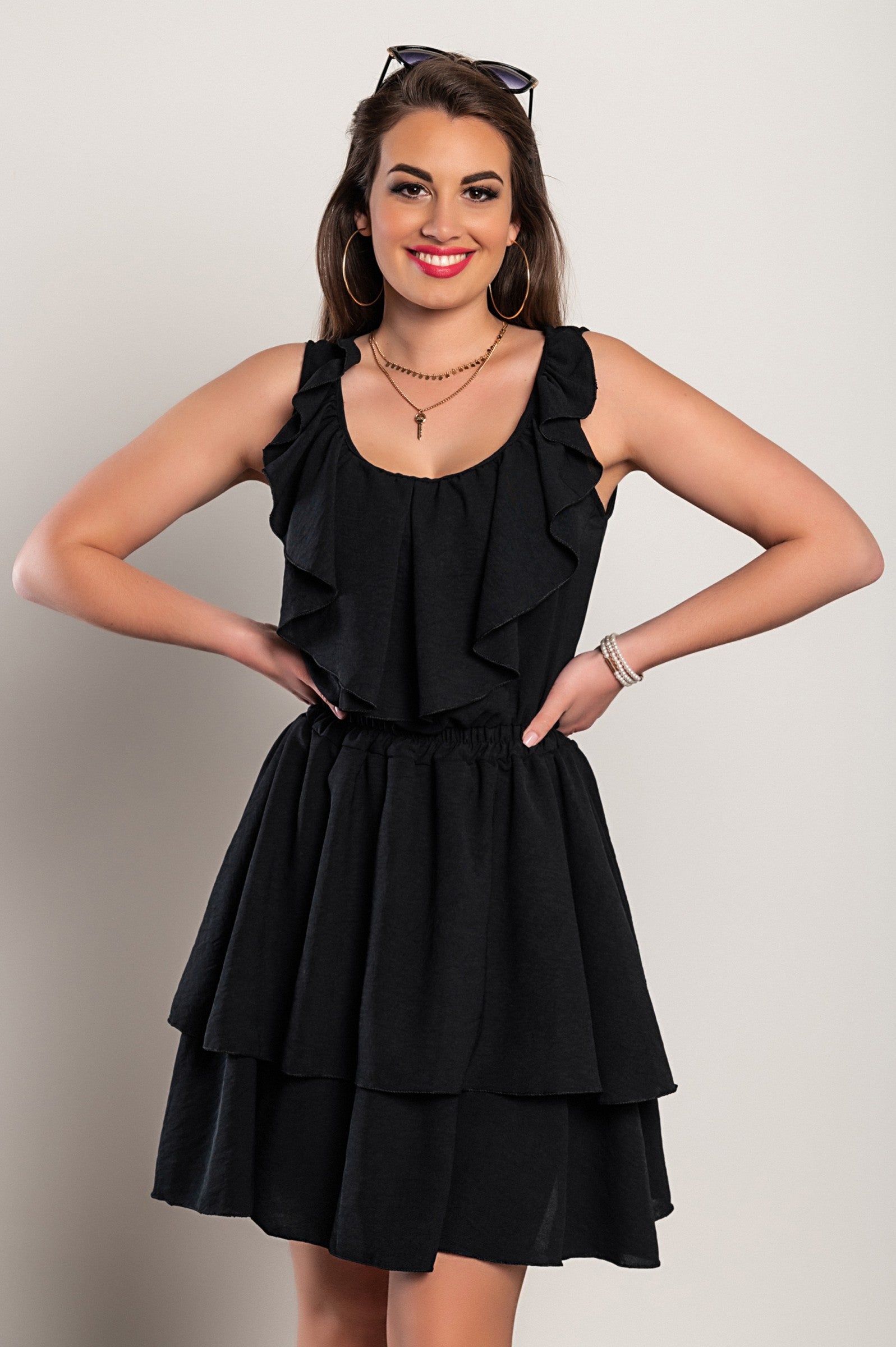 Elegant black mini dress with ruffles, plunging neckline, and wide straps, showcasing a flattering silhouette.