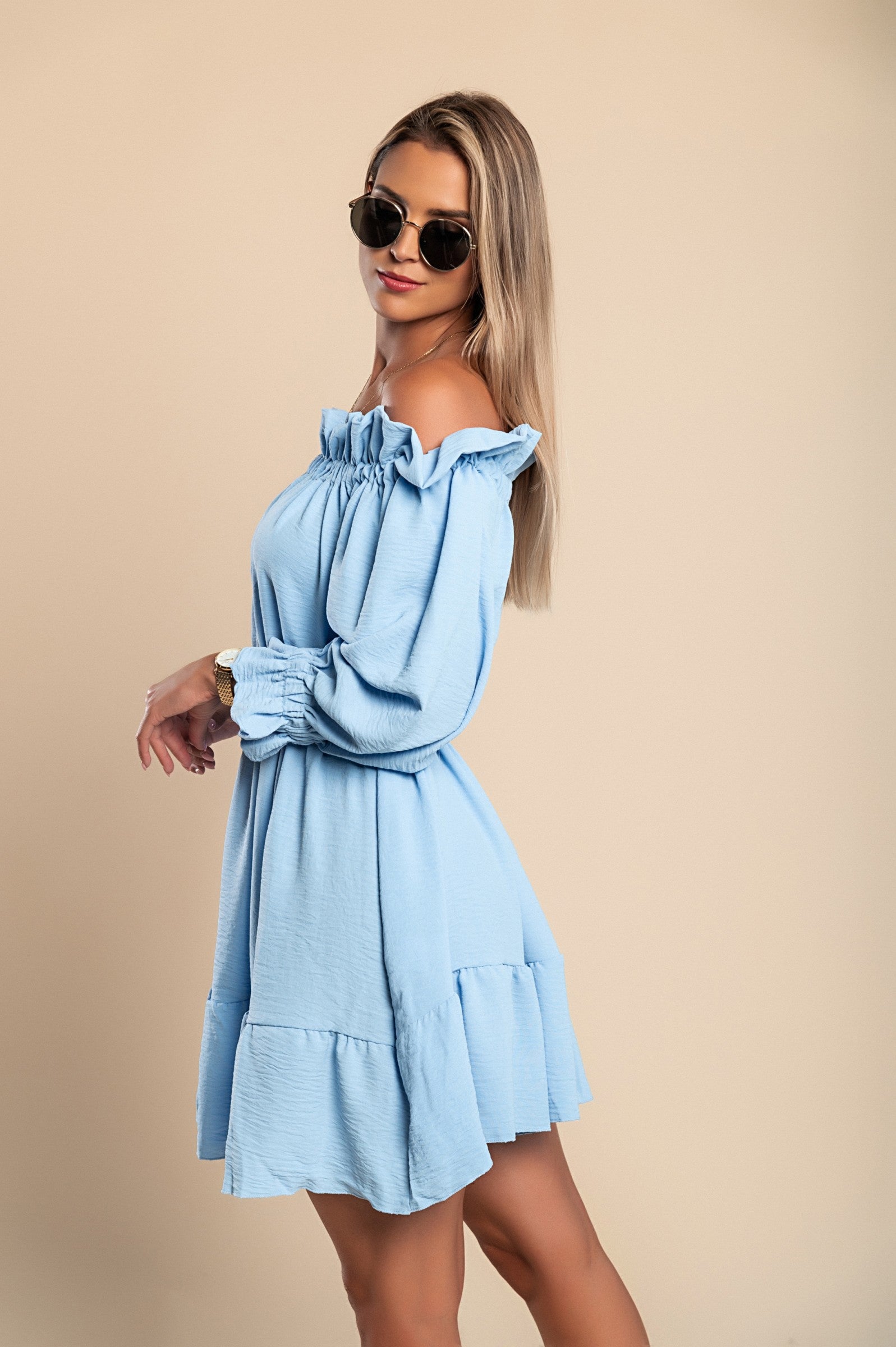 Elegant light blue mini dress with ruffles, featuring a bateau neckline and long sleeves, designed for comfort and style.