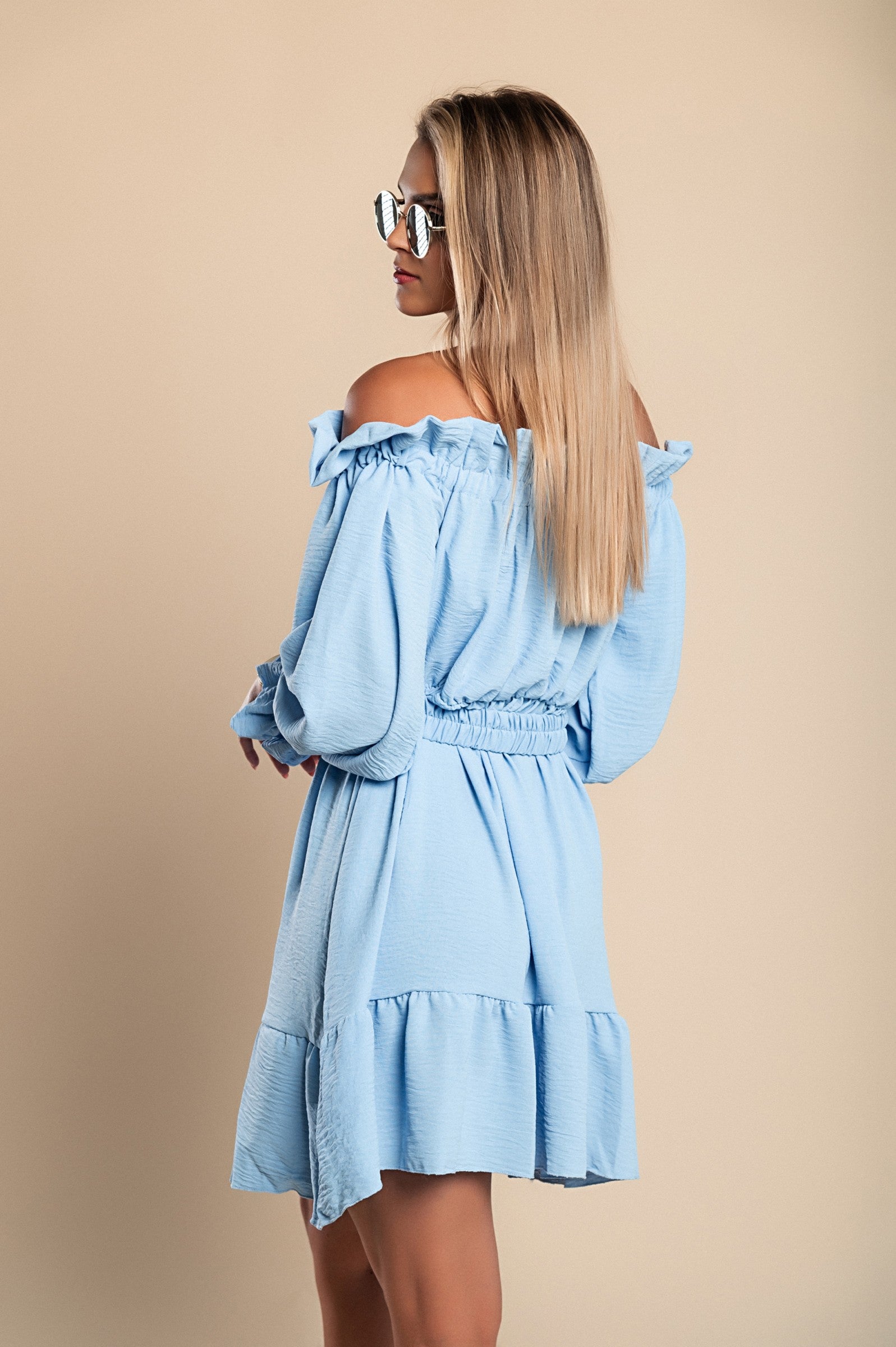 Elegant light blue mini dress with ruffles, featuring a bateau neckline and long sleeves, designed for comfort and style.