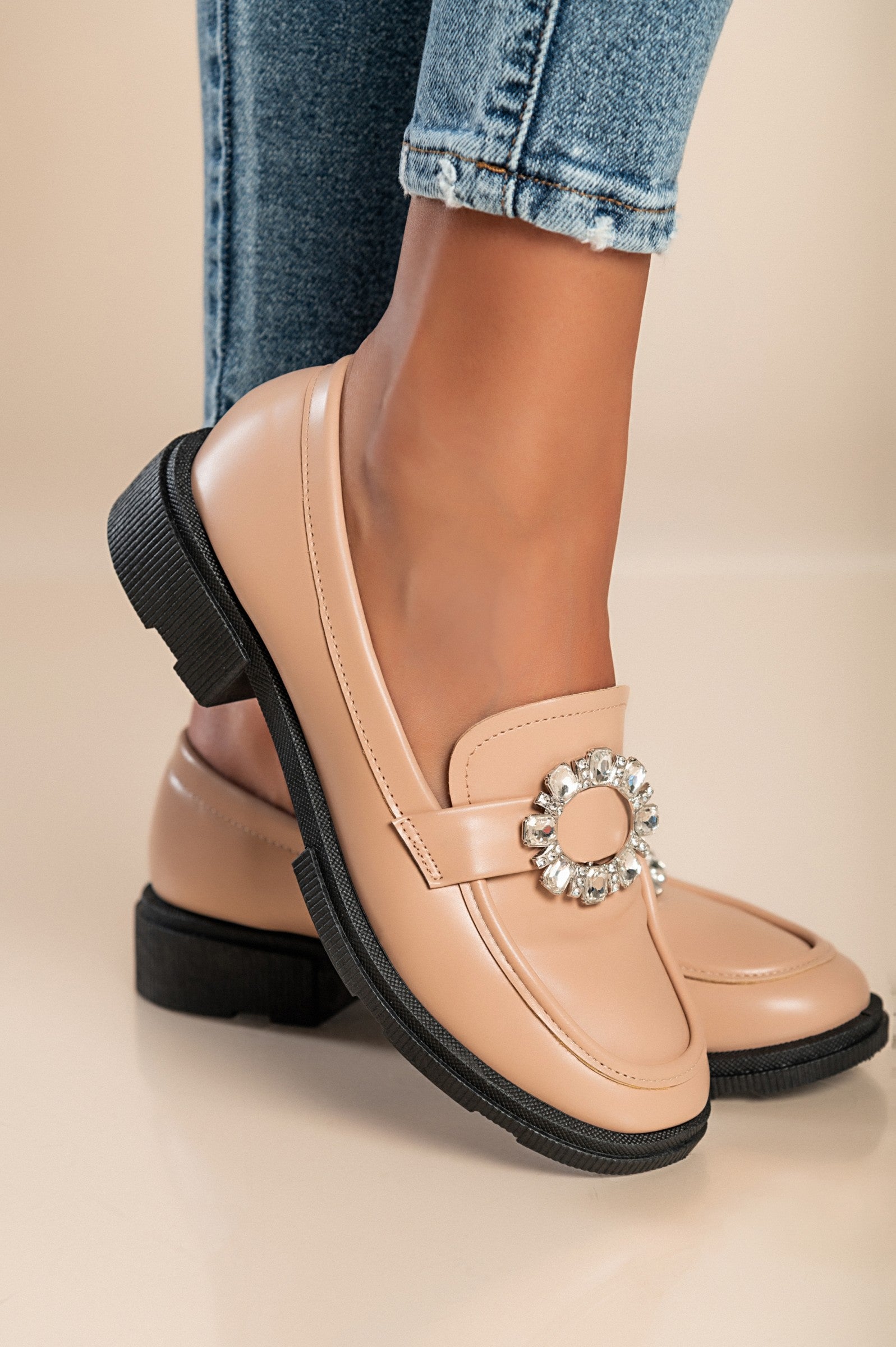 Elegant apricot moccasins with decorative details and flat sole, showcasing round toe design.