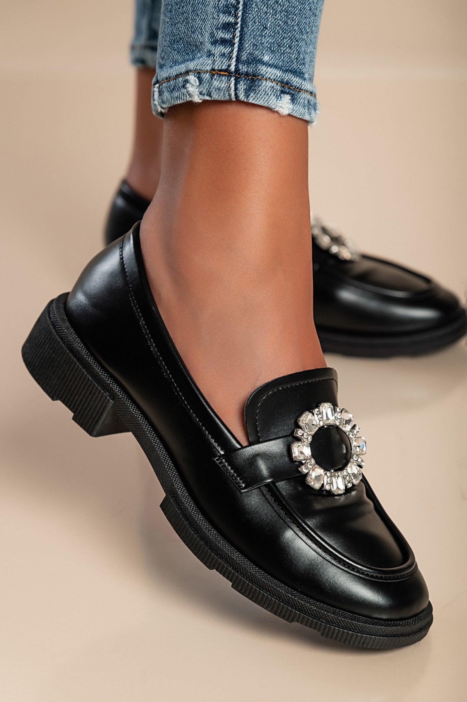 Elegant black moccasins with flat sole and decorative details, showcasing quality craftsmanship and stylish design.