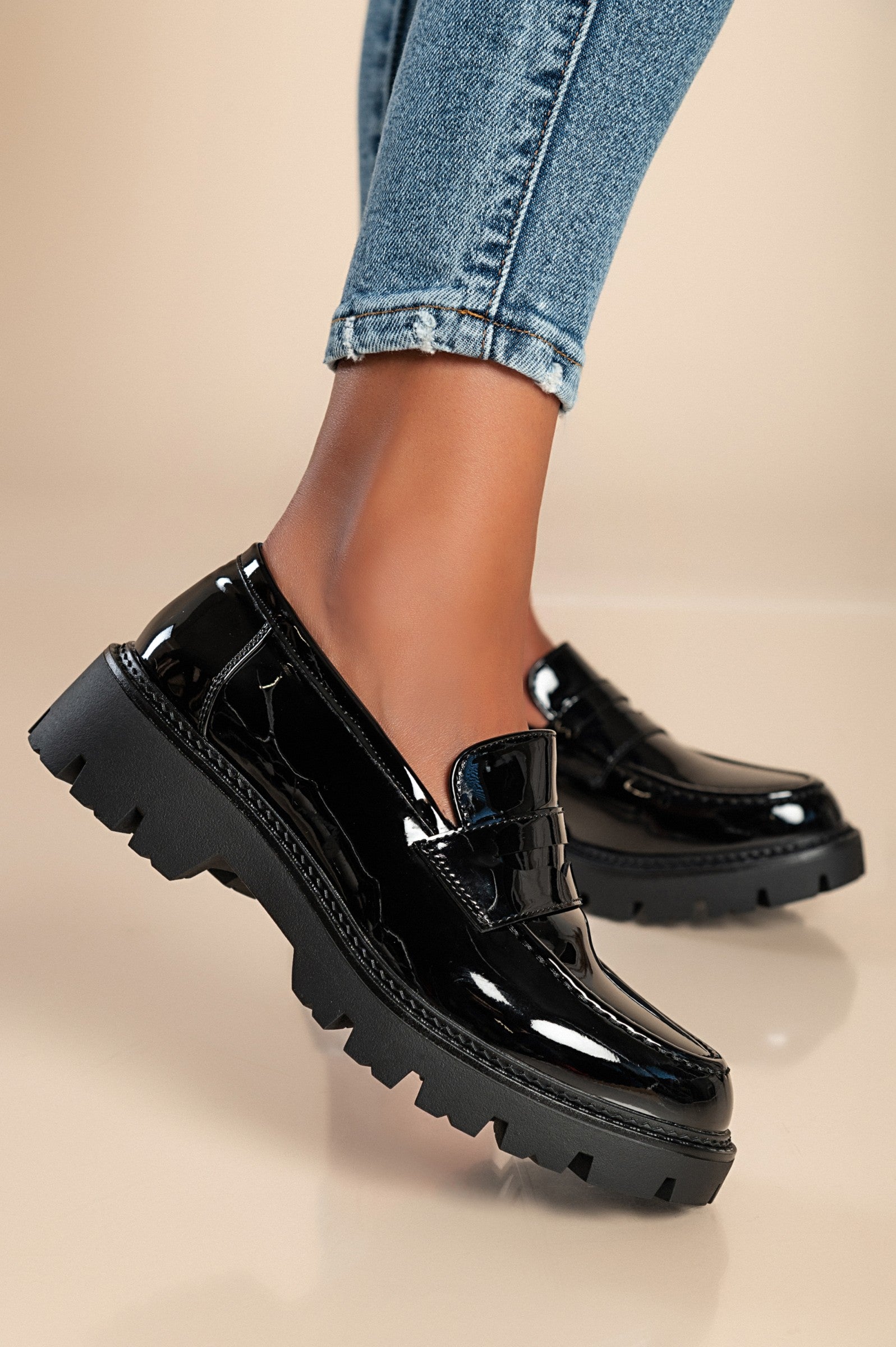 Elegant black mocassins with decorative details and flat sole, showcasing quality craftsmanship and stylish design.