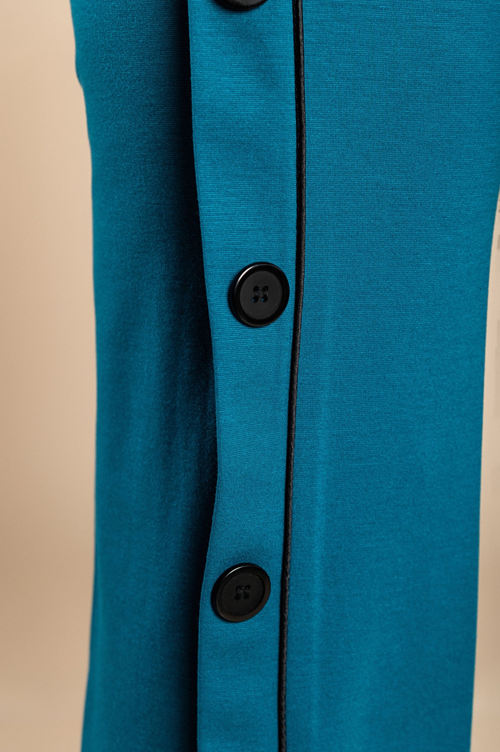 Elegant petrol pants with decorative buttons on the sides and an elasticated waist, showcasing a straight leg design.